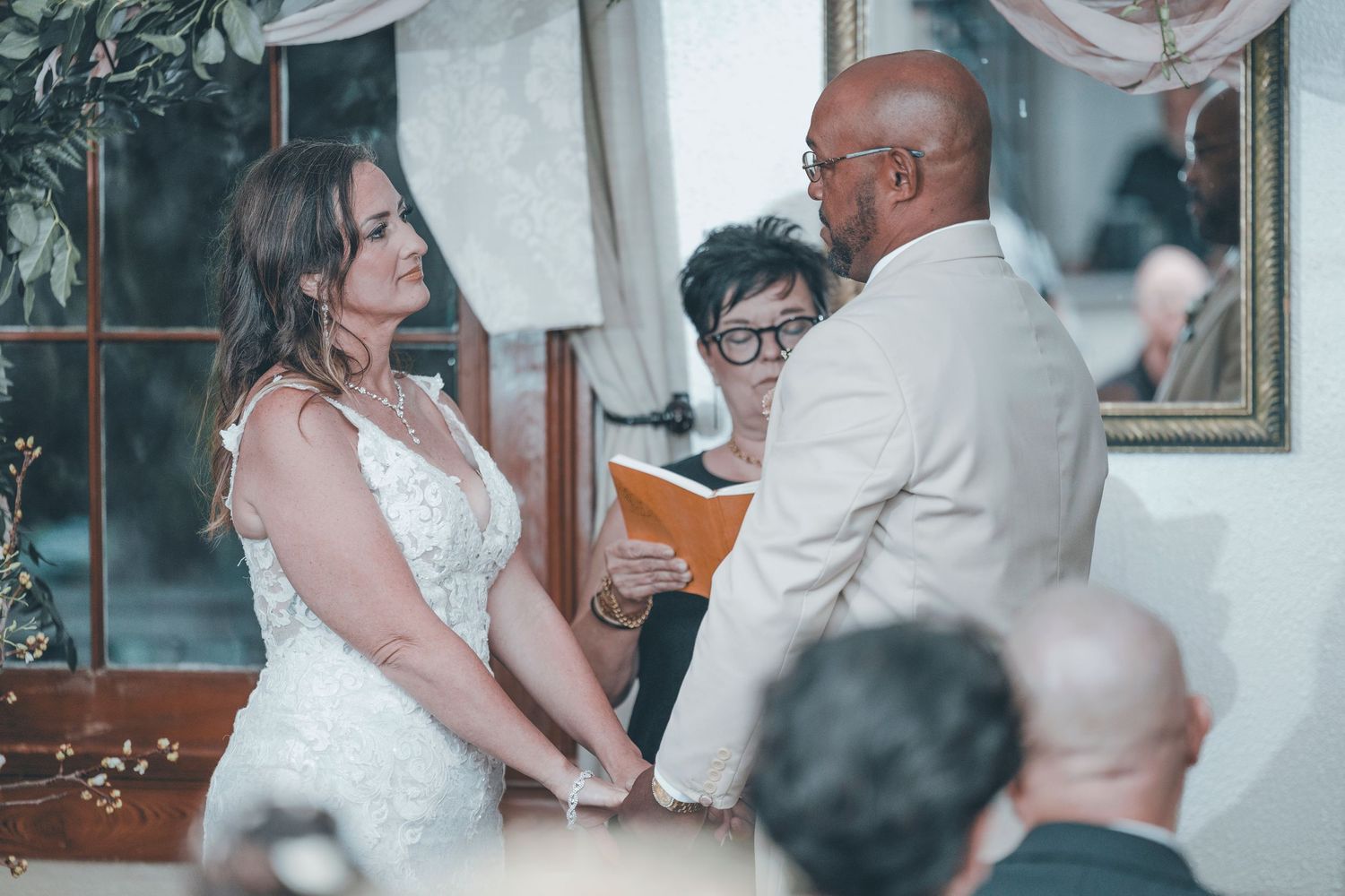 A father and daughter share an emotional first dance at a wedding reception in a beautifully decorated venue.