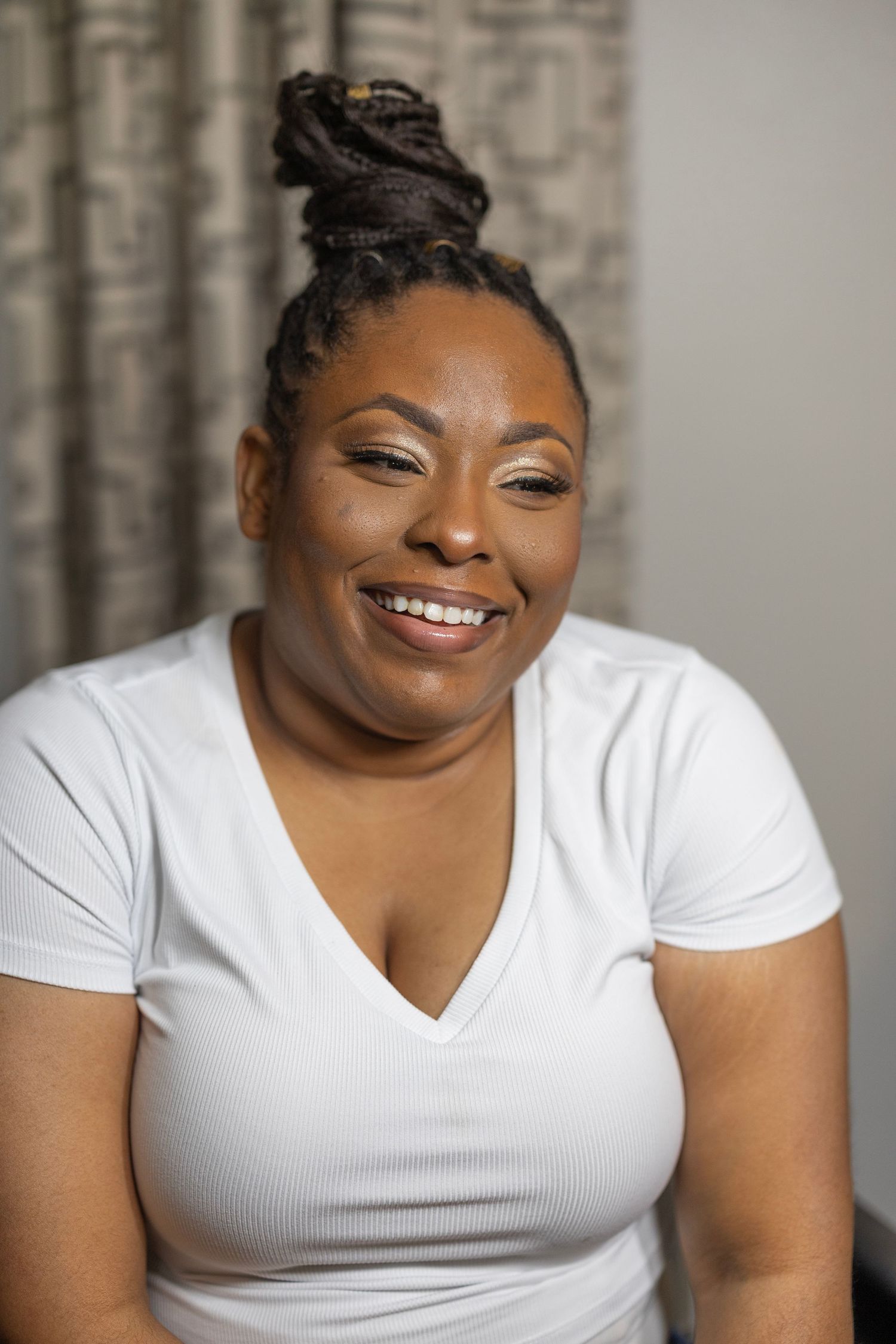 A series of four portraits showing a person in a white v-neck shirt expressing joyful emotions against a gray background.