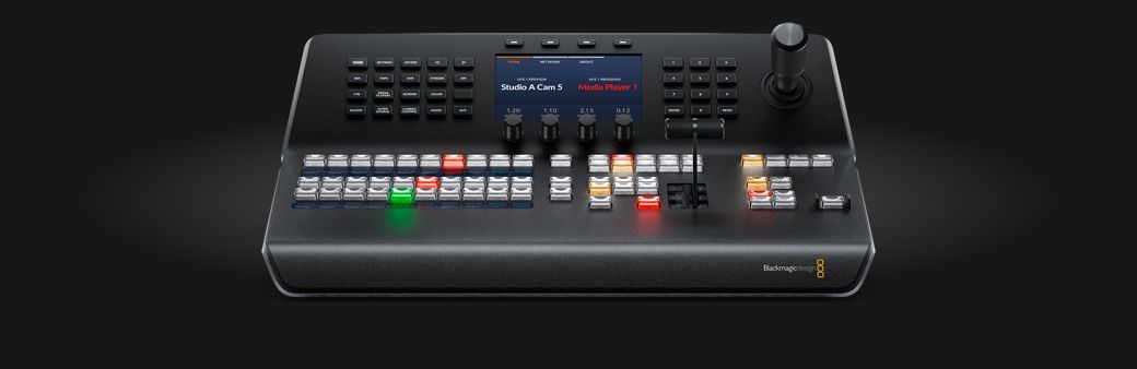 Professional video switcher control panel with illuminated buttons and sliders on black background.