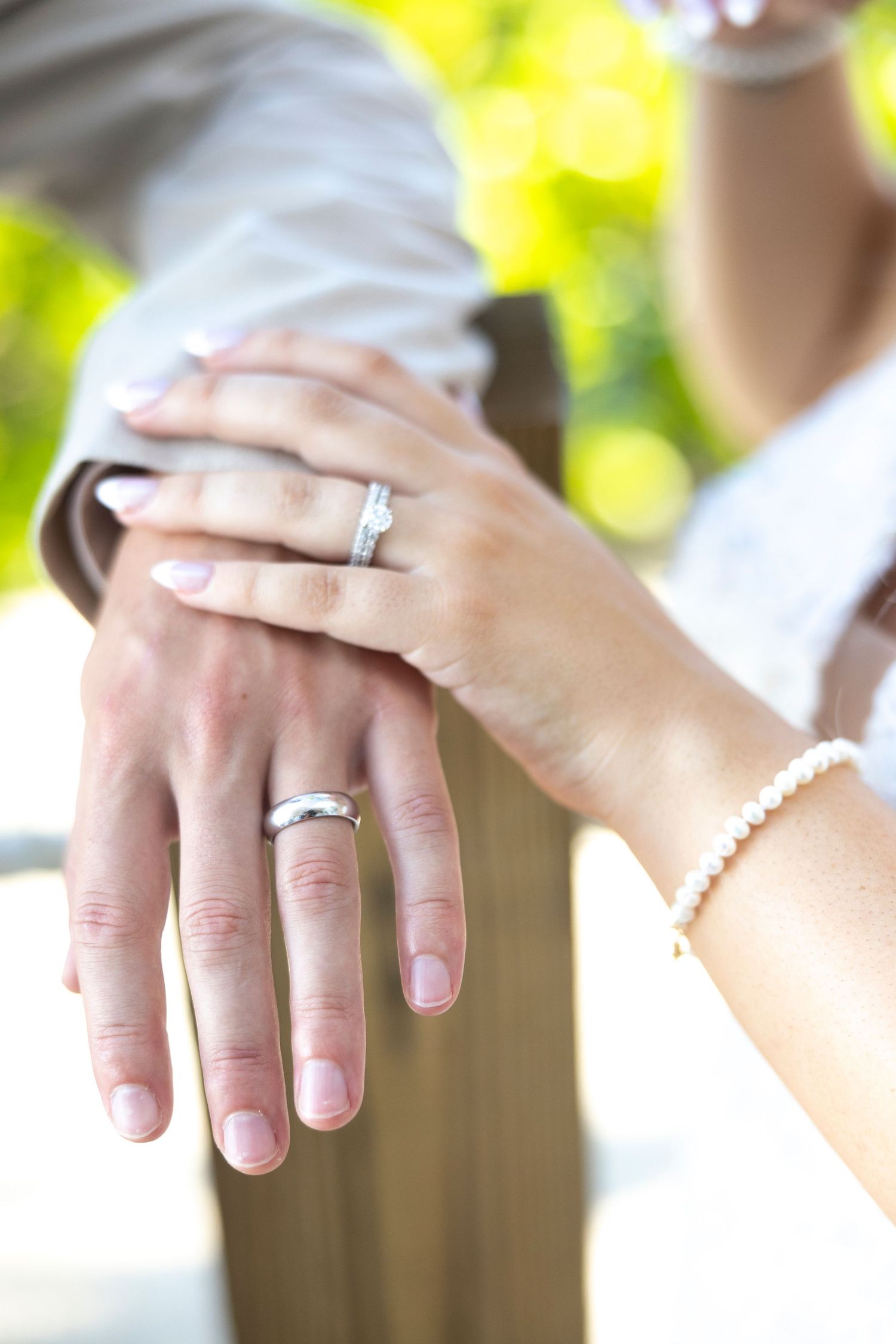 Close-up series of hands showing off an engagement ring with a sparkly diamond solitaire in natural lighting.