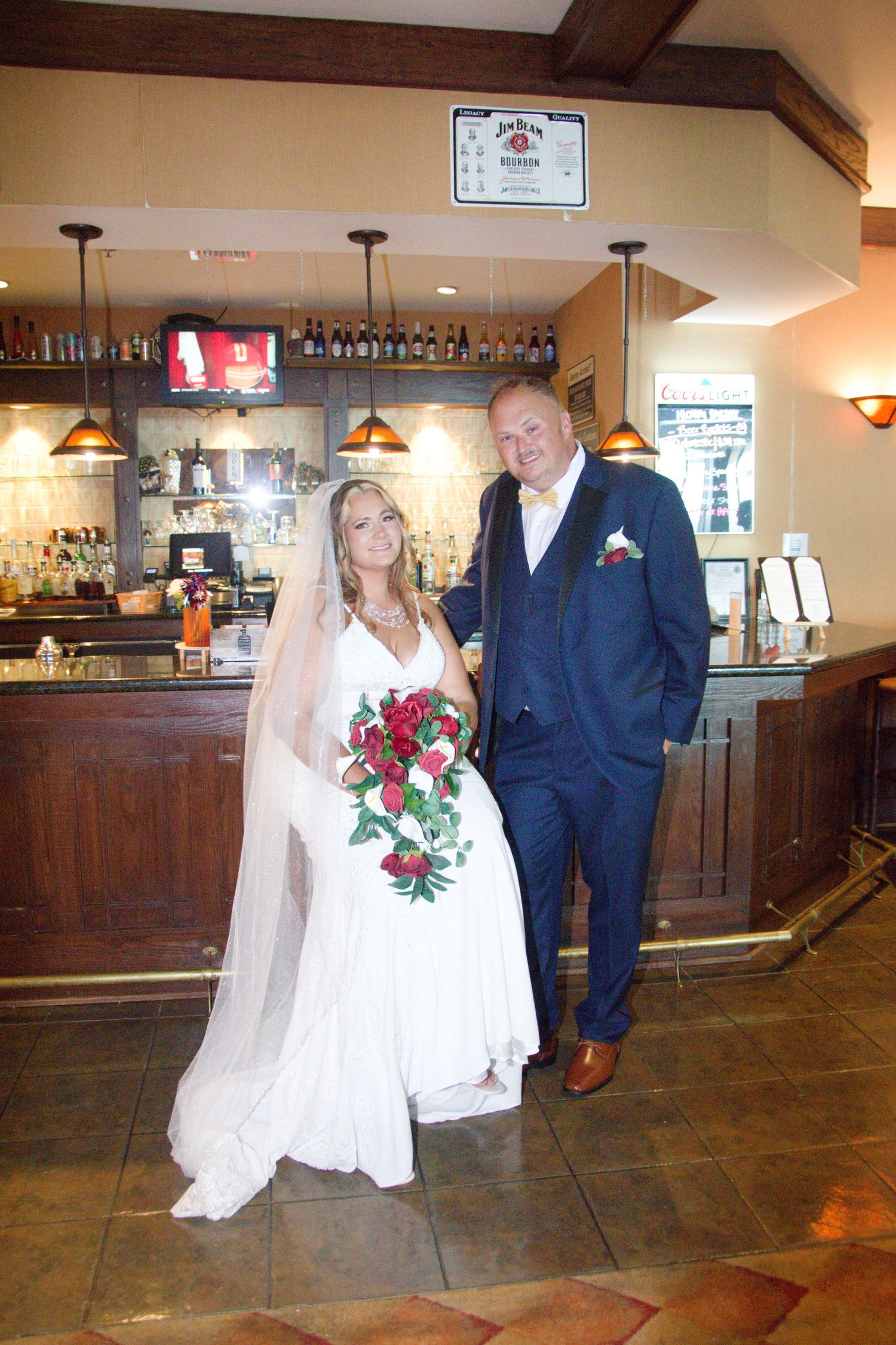 Wedding couple poses together in a rustic bar venue with wooden decor and warm lighting.