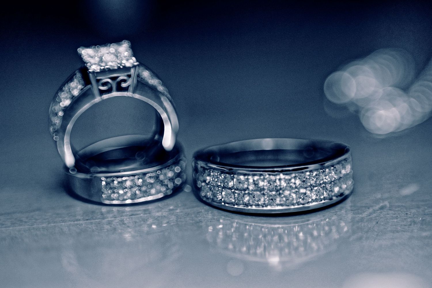 Elegant diamond wedding and engagement rings shown in a series of artistic monochromatic close-up shots.