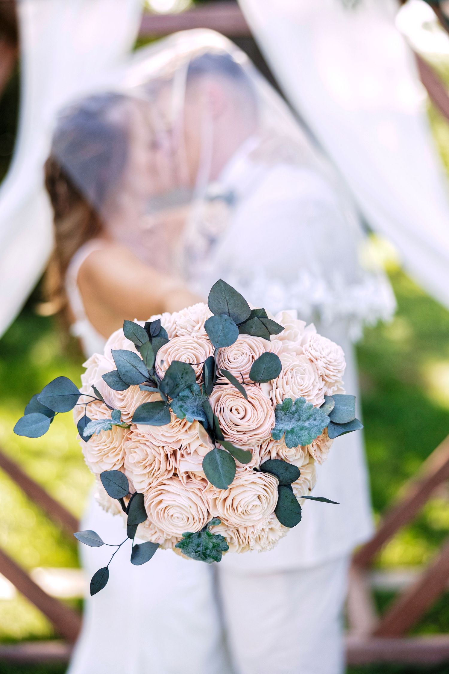 A delicate floral arrangement featuring soft pink roses and eucalyptus leaves creates an elegant wedding decor detail.