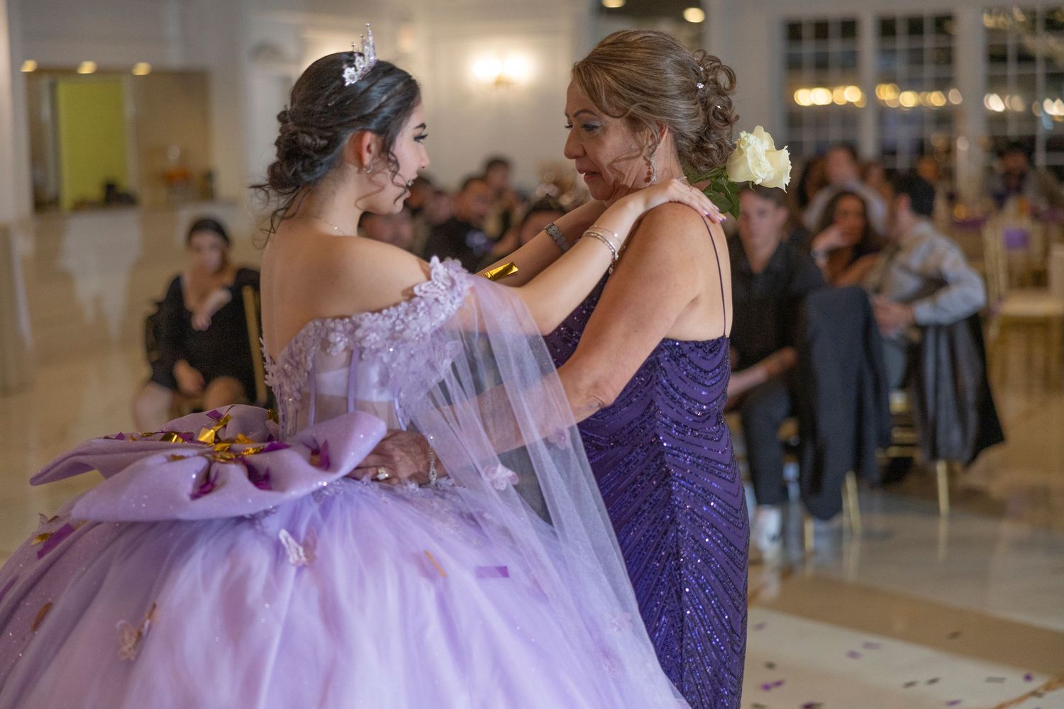 A group of dancers in purple and lavender dresses perform together at a formal event.