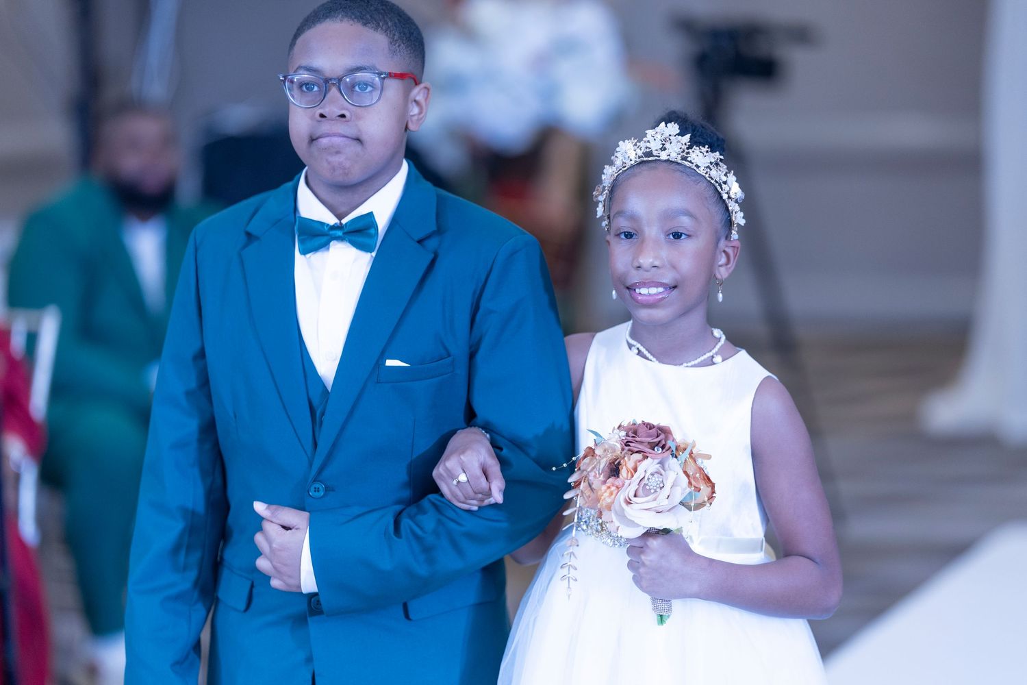 Wedding party members in formal attire dance and celebrate during a reception.