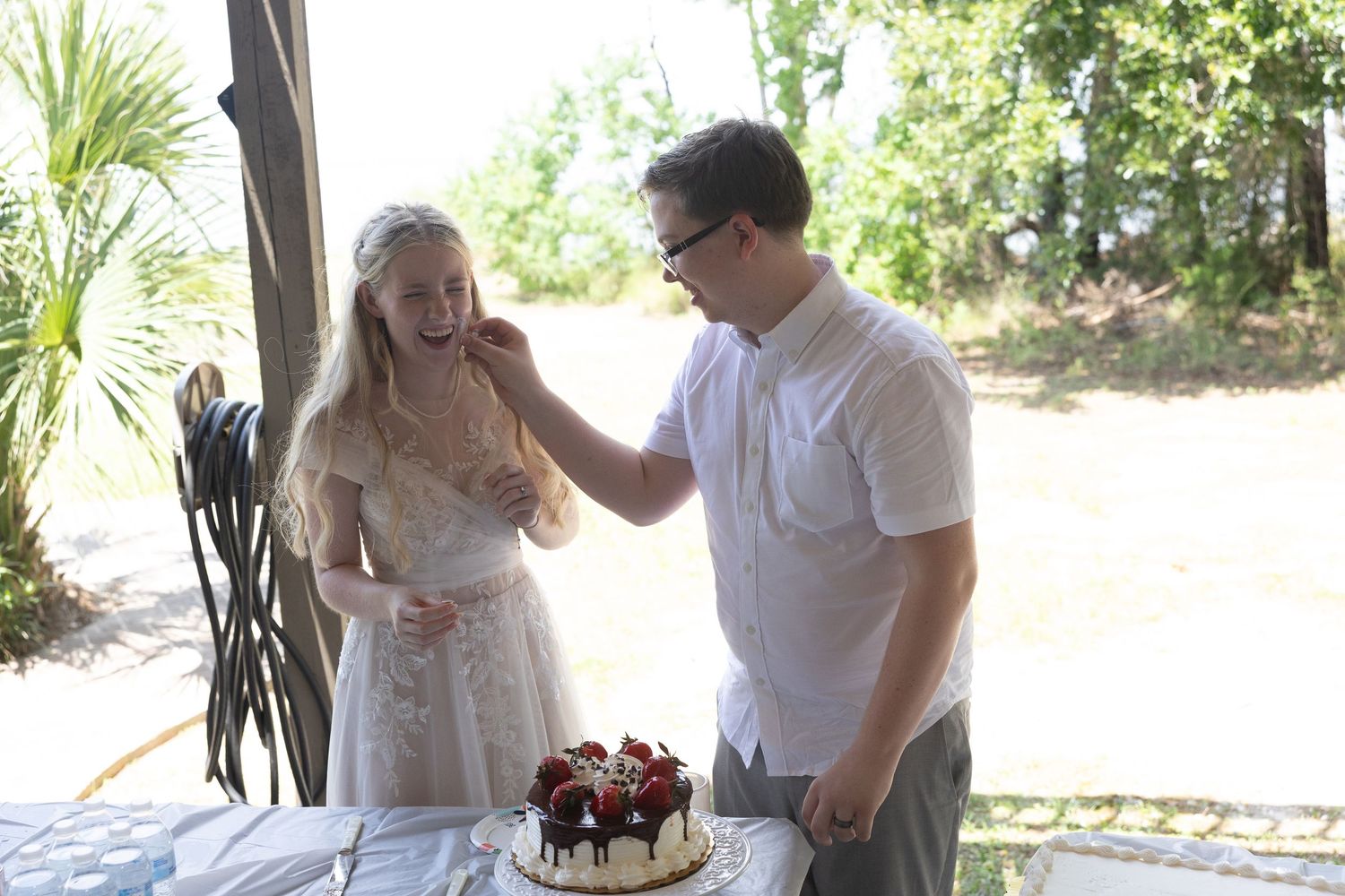 Couple sharing romantic moments in a garden setting during an outdoor wedding photoshoot.
