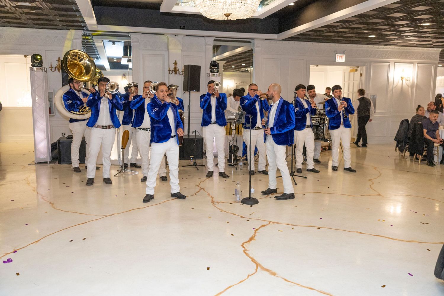 A panoramic view of a large indoor facility with people in blue and white uniforms gathered for an event.