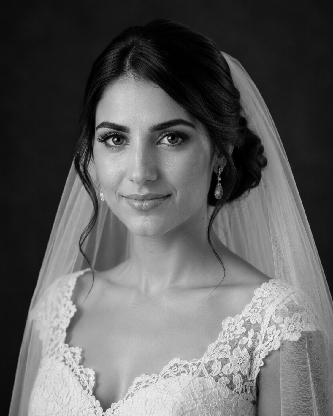 Black and white bridal portrait of a brunette bride wearing lace wedding dress and veil with elegant updo.