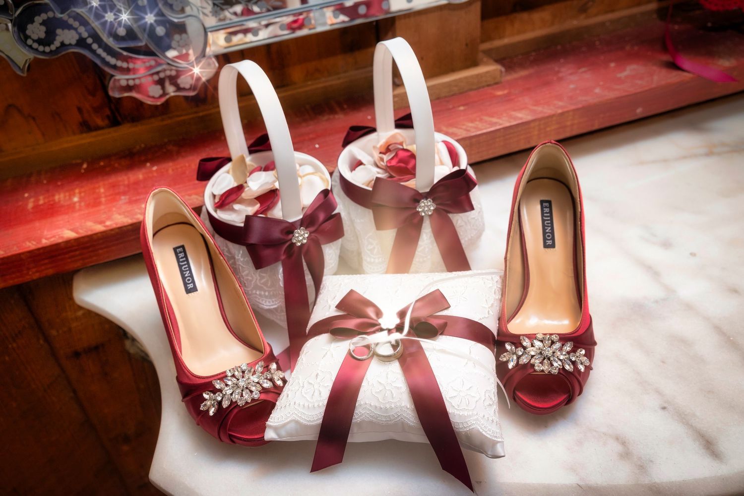 Elegant burgundy and white wedding shoes and matching hair bows with crystal embellishments.