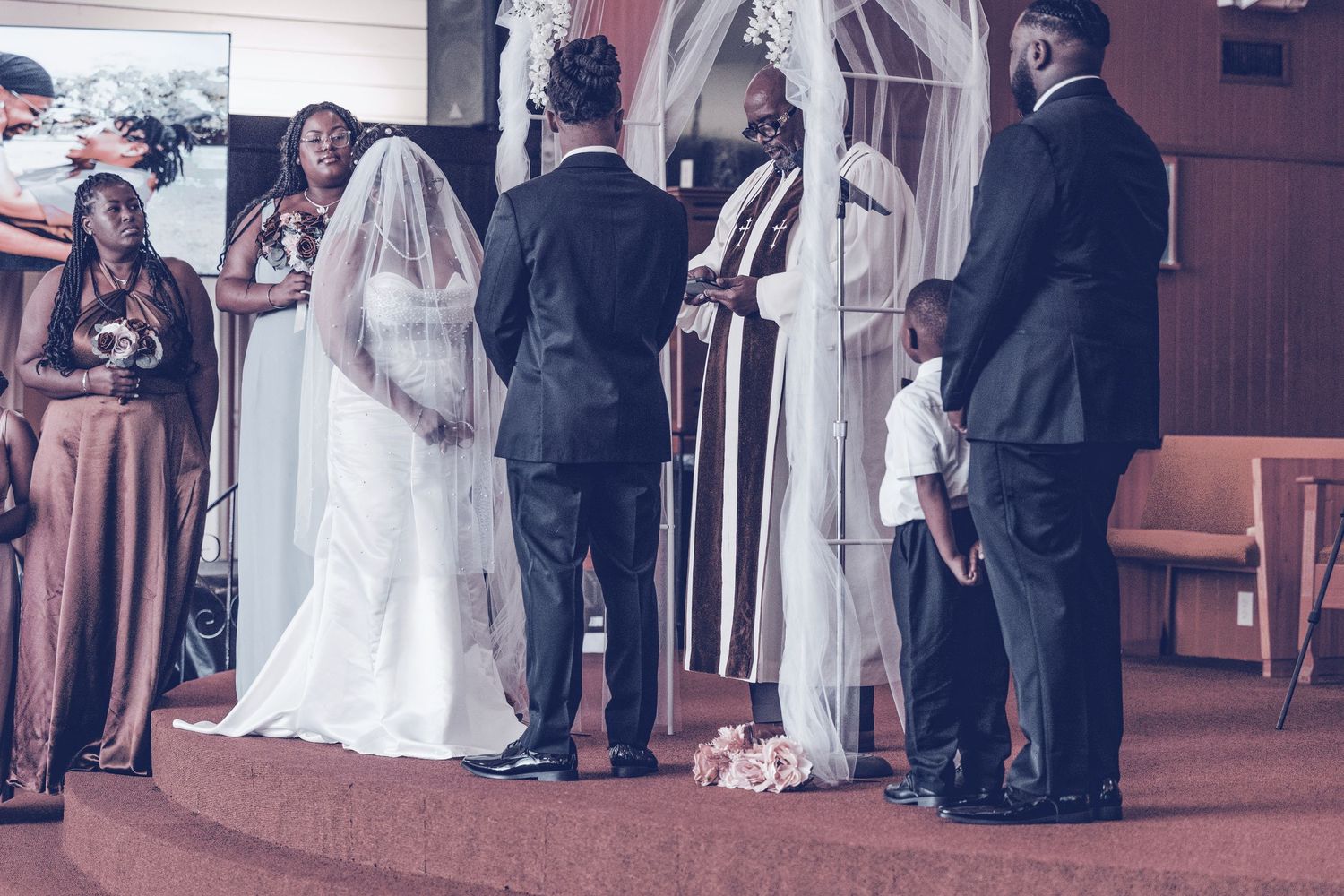 Wedding party gathers in a church hallway during a traditional ceremony celebration.
