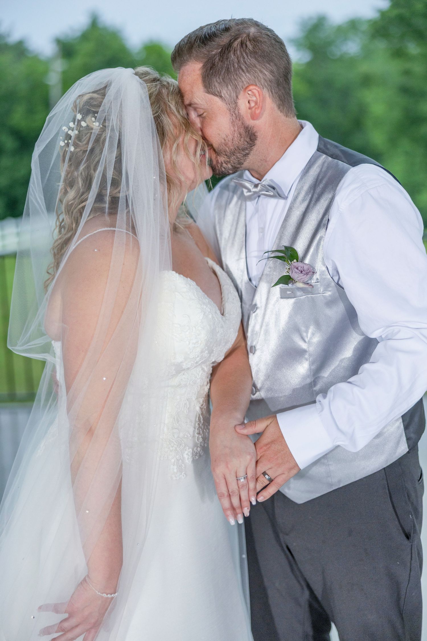 A sequence of wedding photos shows a tender romantic moment between newlyweds in white and gray attire outdoors.