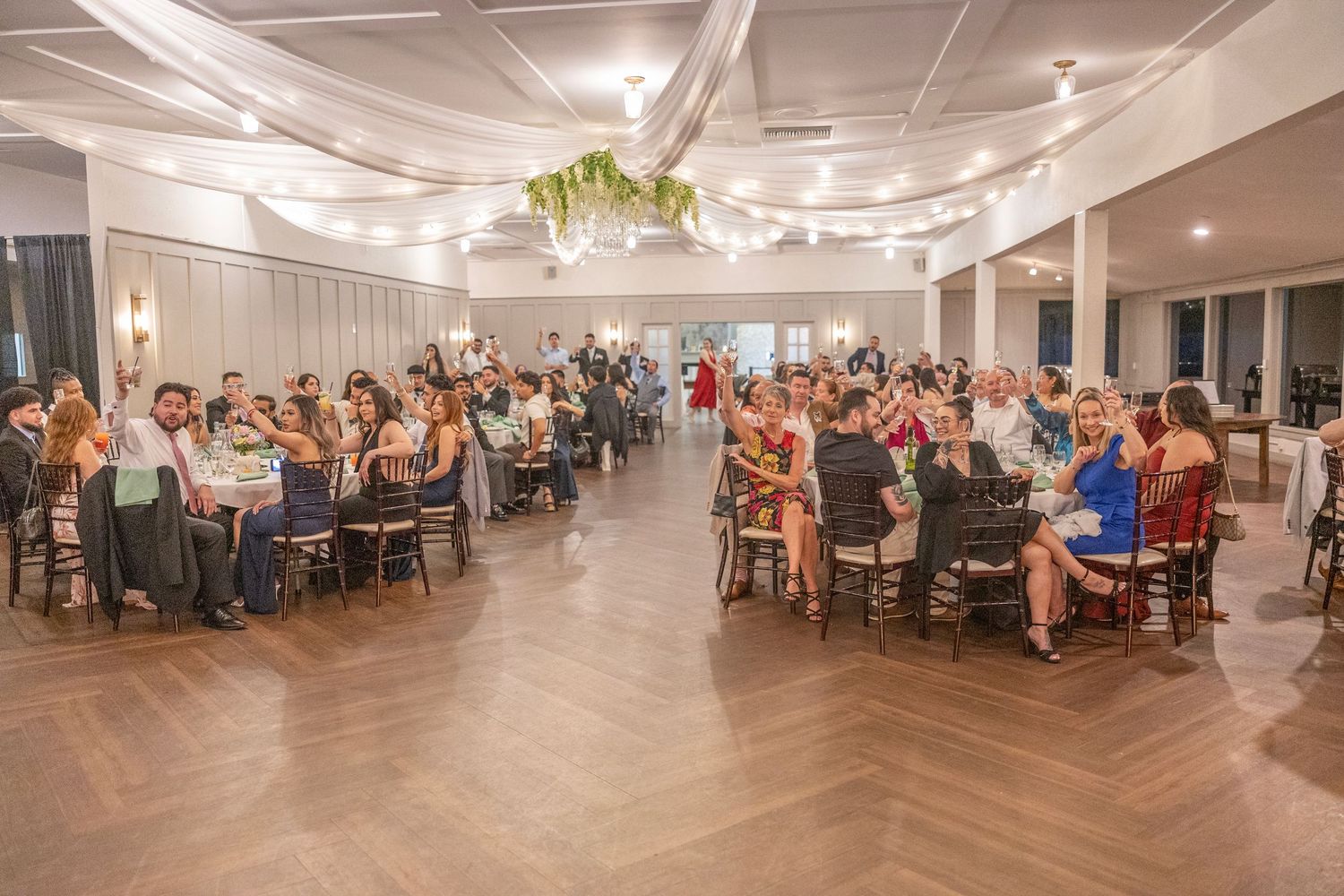 Elegant banquet hall filled with guests seated at round tables during a formal dinner reception event.