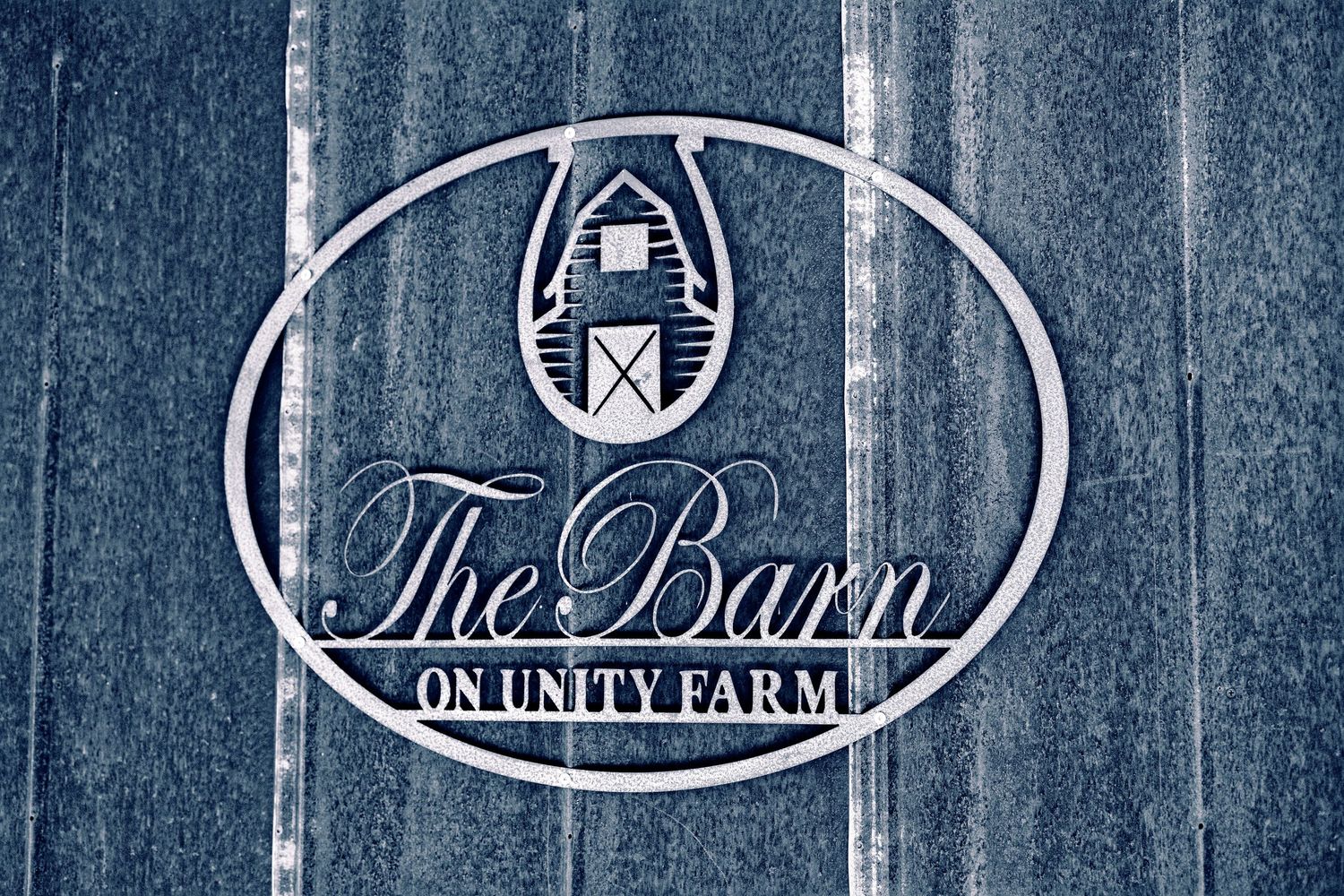 Row of rustic wooden signs with farm and barn themed logos displayed on blue weathered wood background.