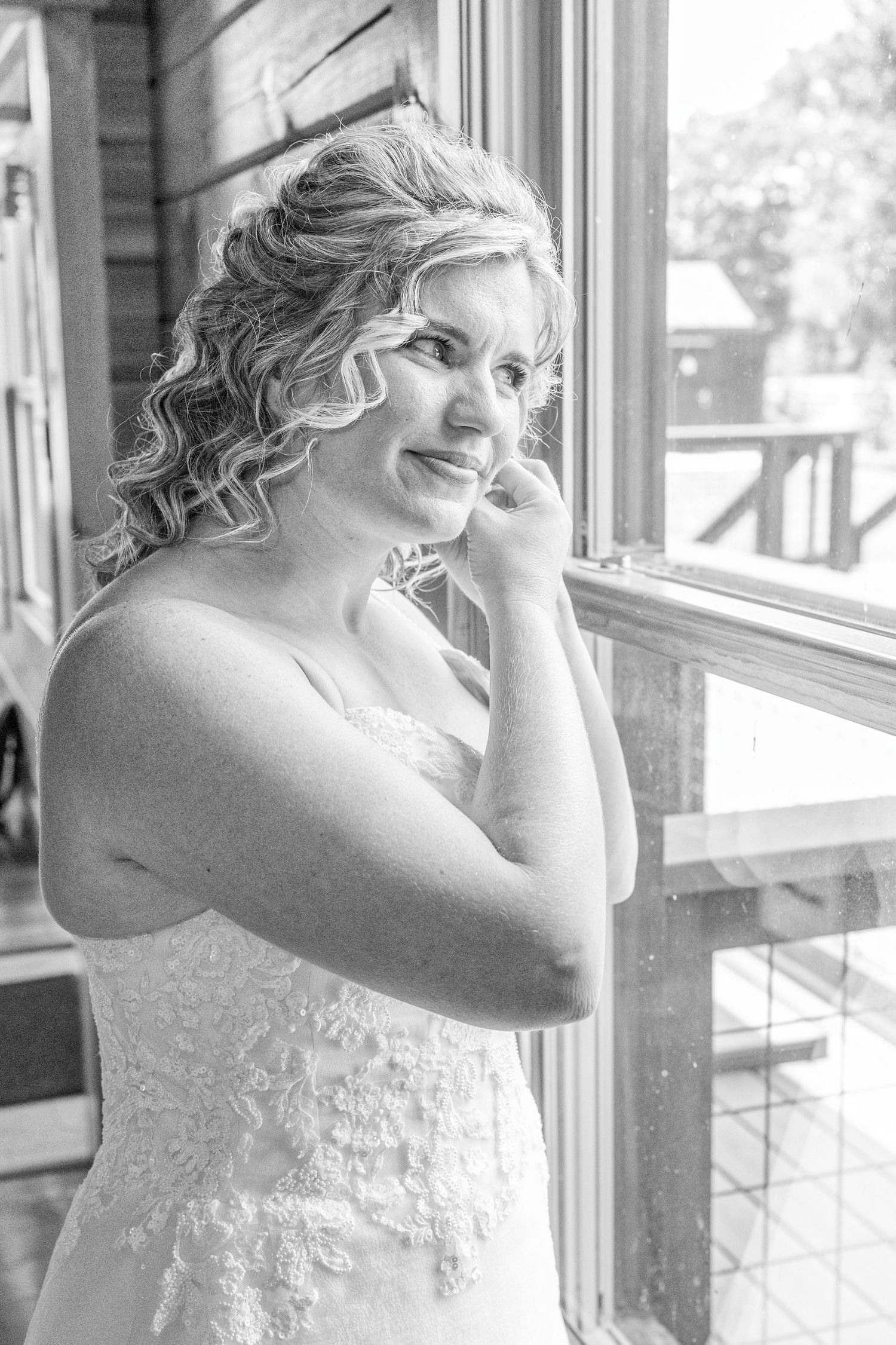 A sequence of black and white photos showing someone in a white lace dress looking out a window.