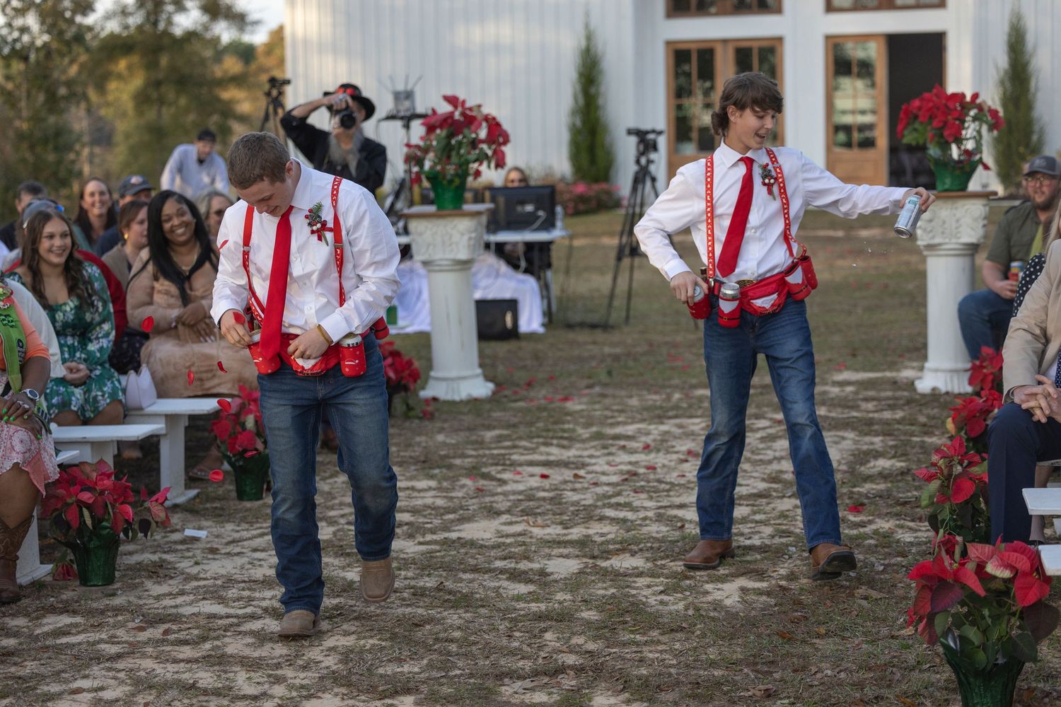 Group of people in jeans and red holiday attire gathering outdoors for a festive event.