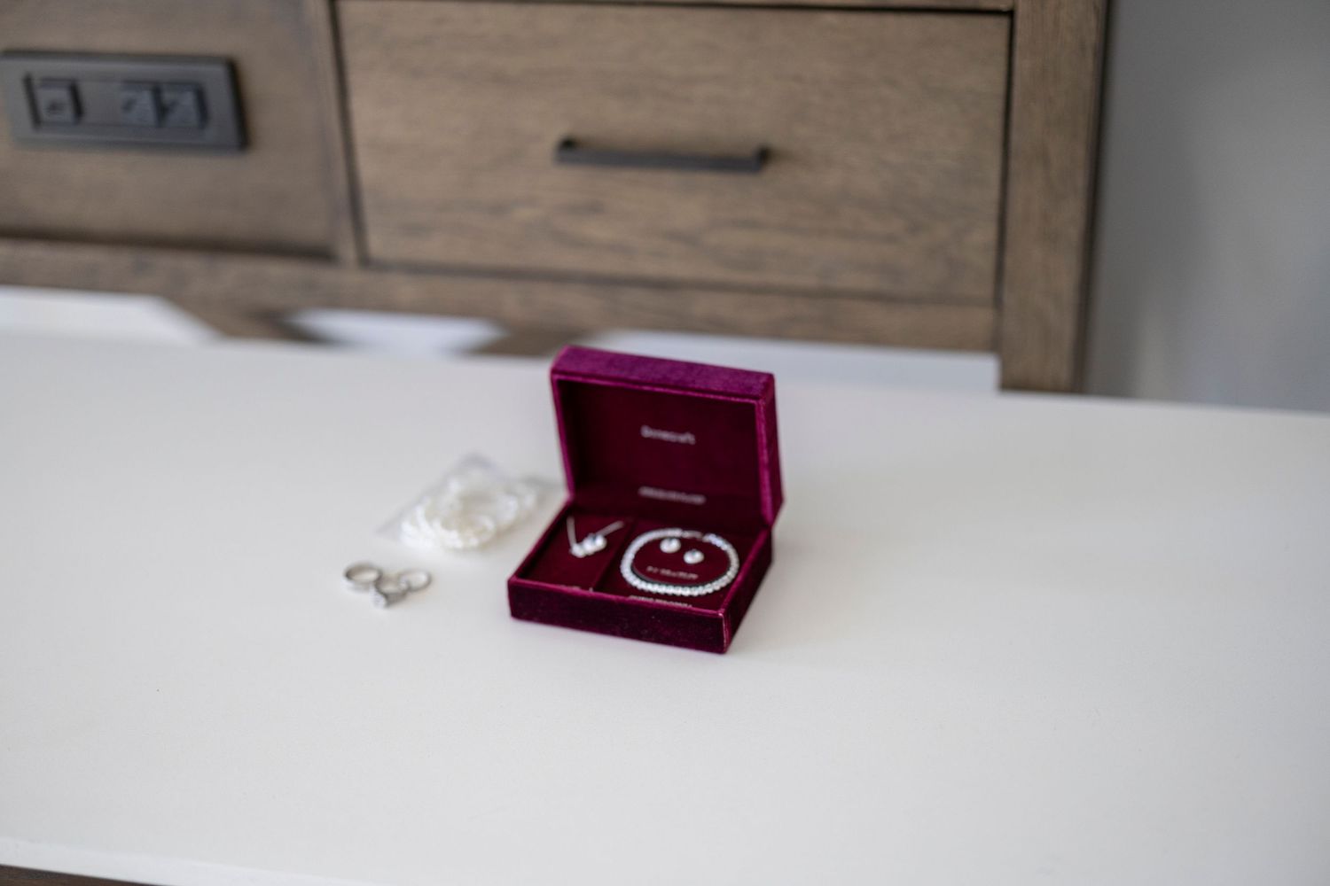 A luxury watch box sits on a white surface with a blurred background showing additional watch boxes.