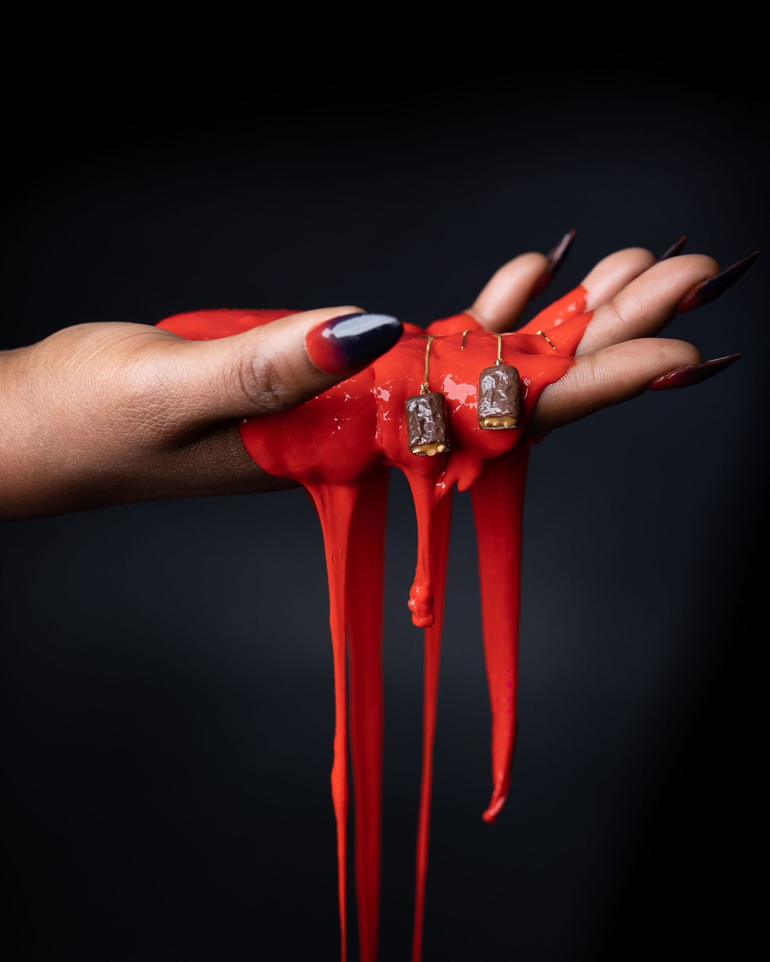 Red dripping liquid creating dramatic streaks against black background.