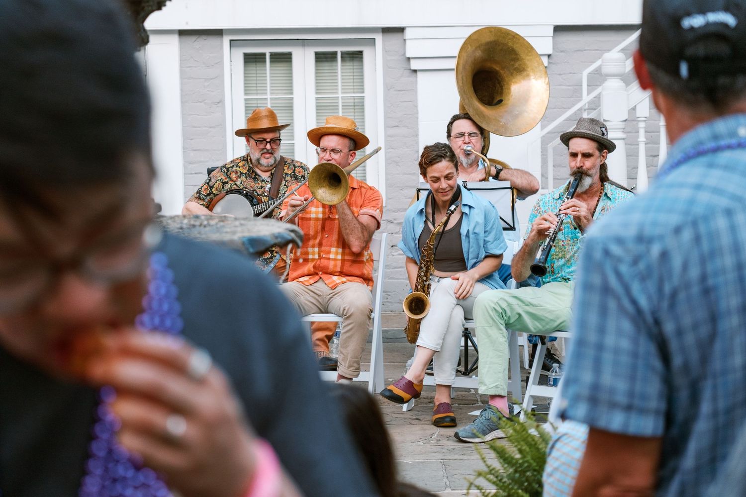 Outdoor gathering scene with people socializing on a porch.