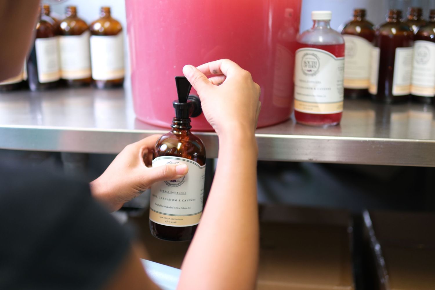 Hands reaching for glass jars on shelves in what appears to be a retail setting.