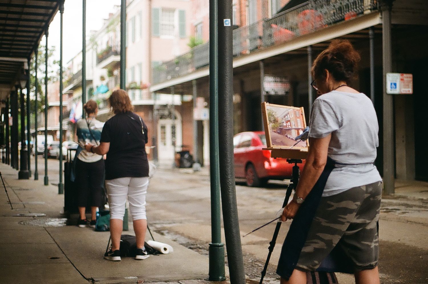 Street scene in New Orleans with covered walkways and people walking along sidewalk.
