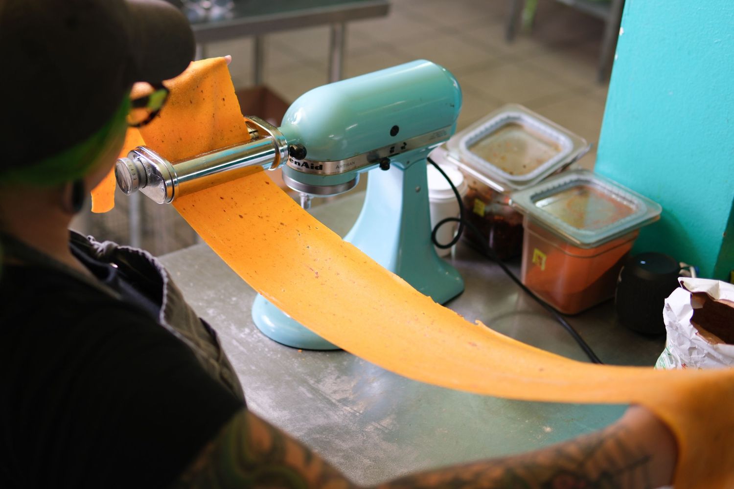 Close-up view of a sewing machine stitching orange fabric.