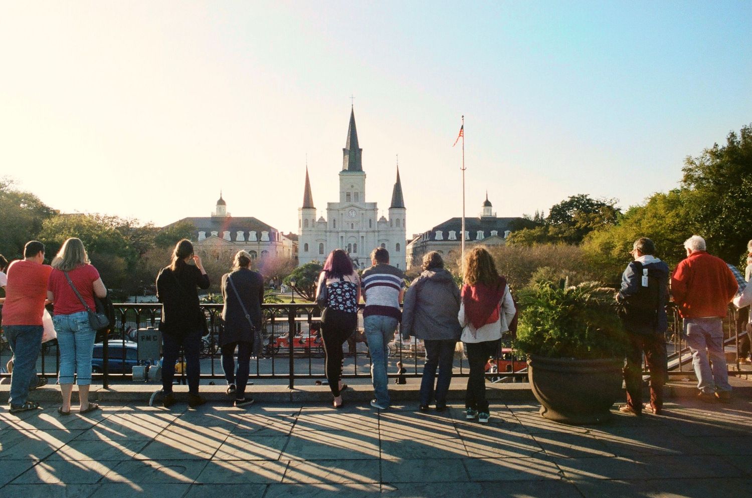 St. Louis Cathedral and Jackson Square in New Orleans viewed through an iron fence at sunset.