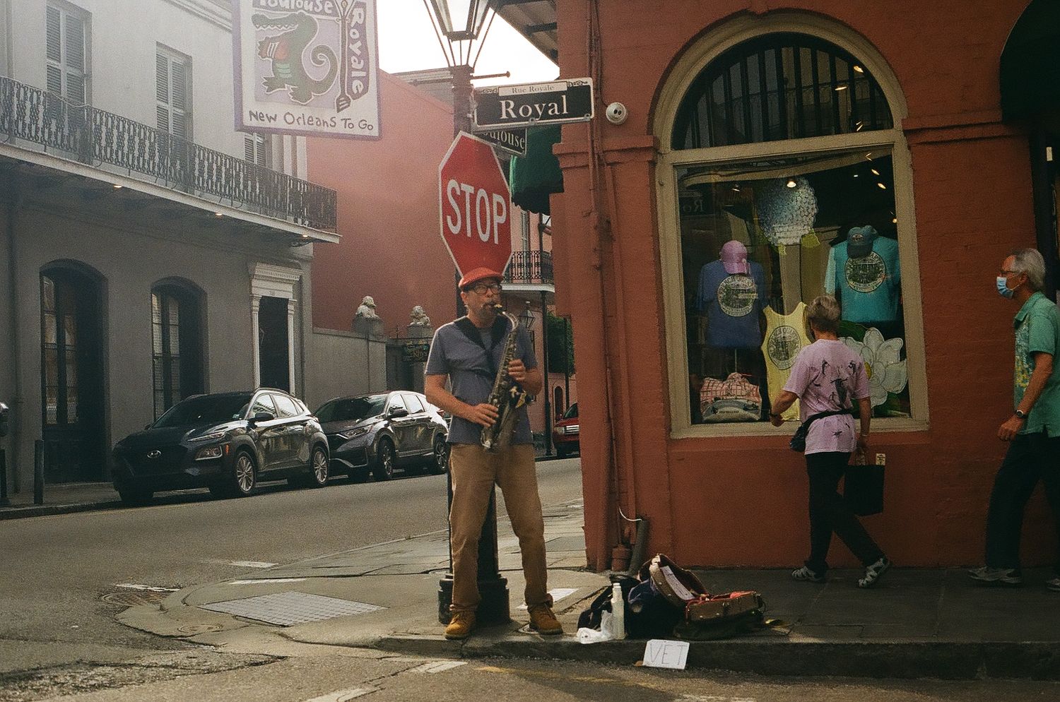 Historic red brick buildings line a street in what appears to be New Orleans' French Quarter.