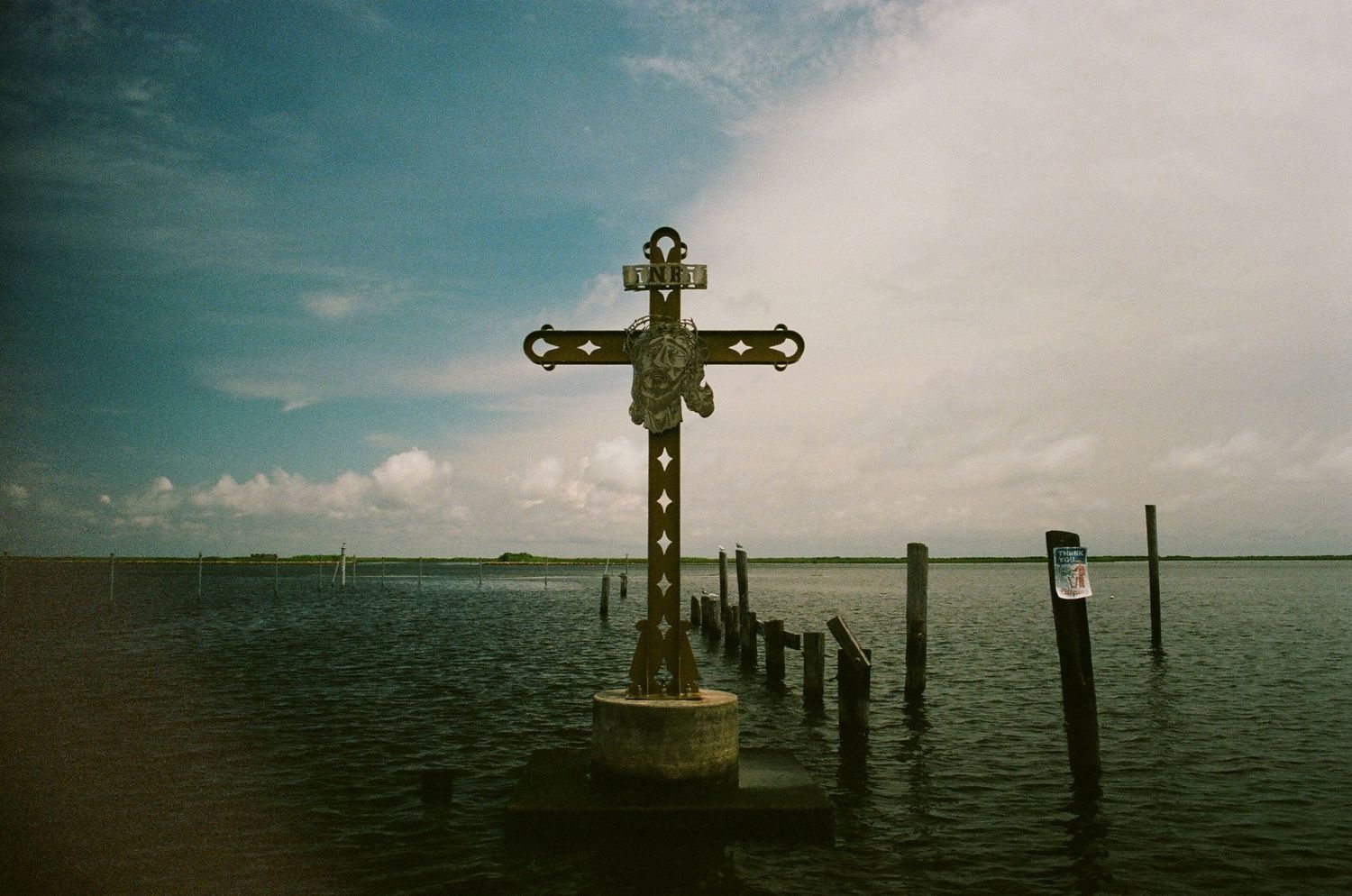 Panoramic view of wooden piers and crosses silhouetted against a waterfront horizon.