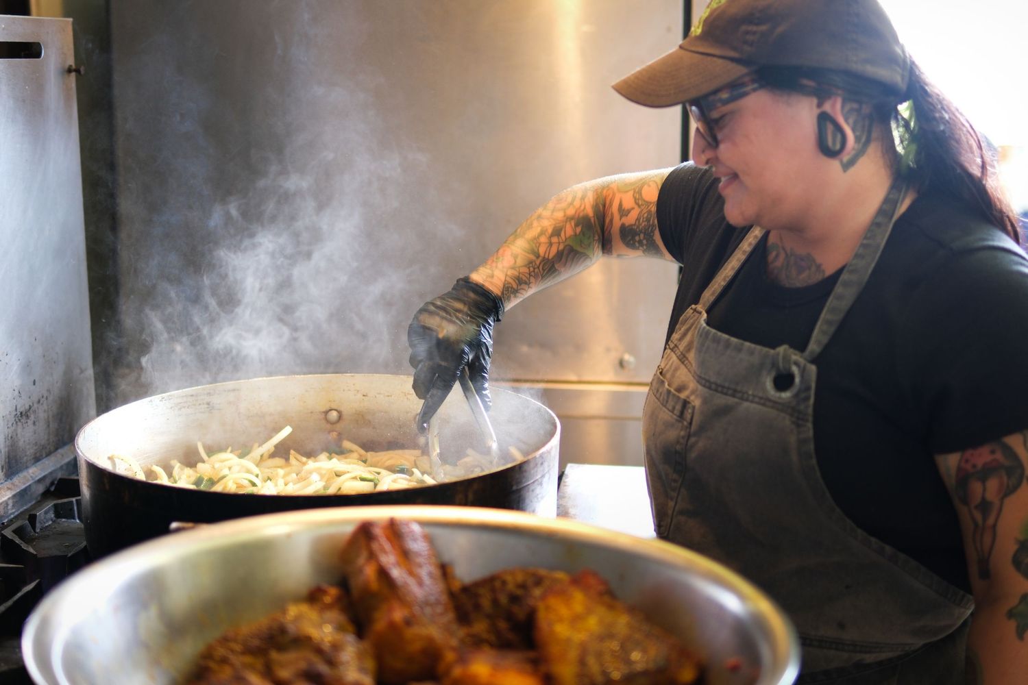 Steam rising from cooking pans in a commercial kitchen setting.