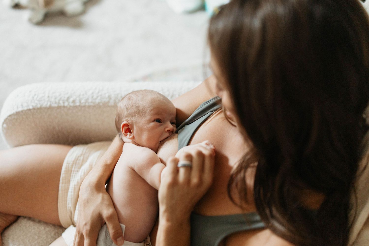 A peaceful newborn photo session shows tender moments between family members in soft natural light.