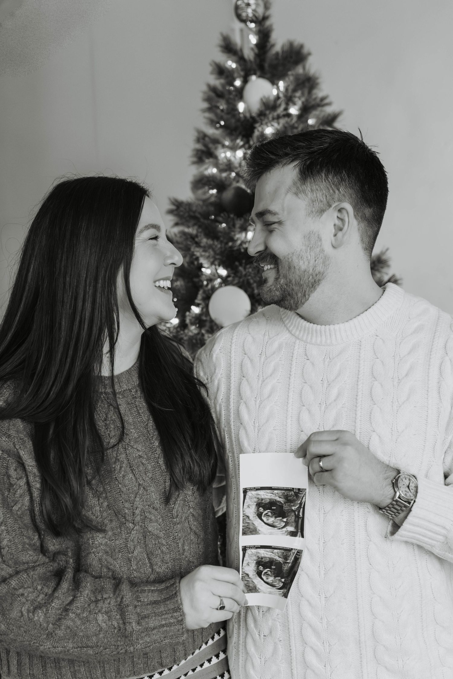 Black and white photo series showing a couple holding ultrasound photos while sharing tender moments together.