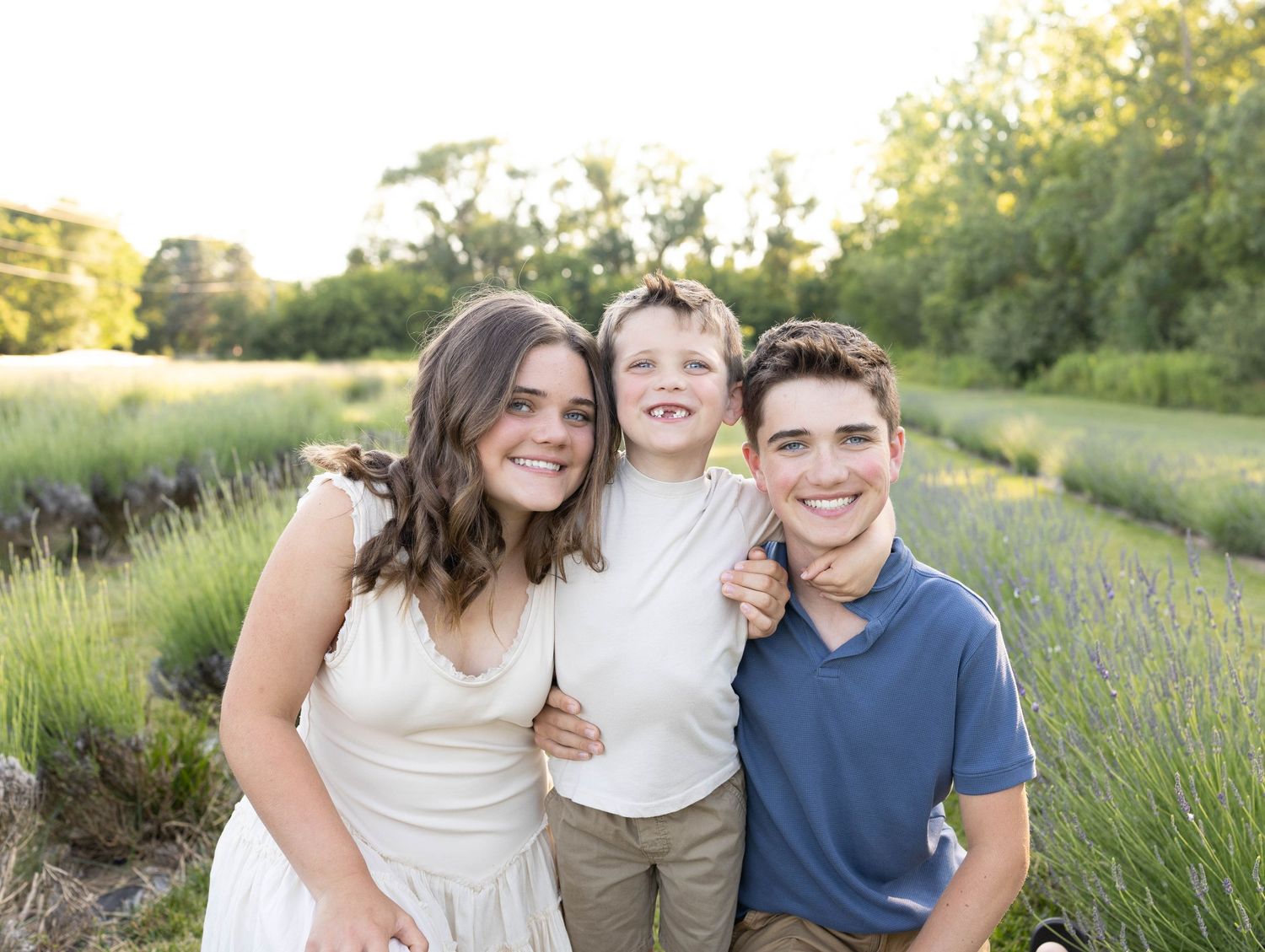 Family portrait in a lavender field at sunset with warm golden light and natural outdoor setting.