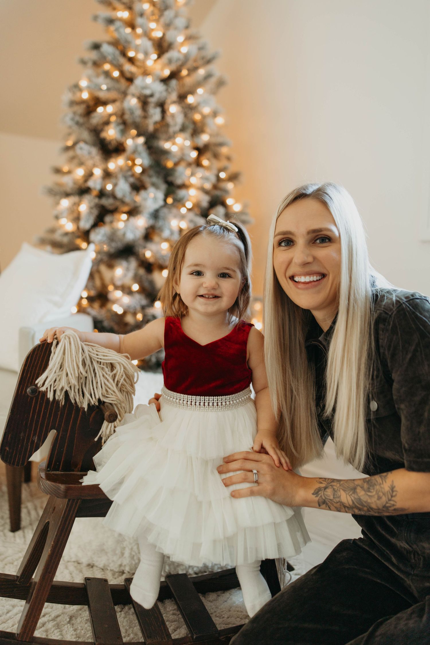 Festive holiday scene with decorated white Christmas tree glowing warmly in the background.