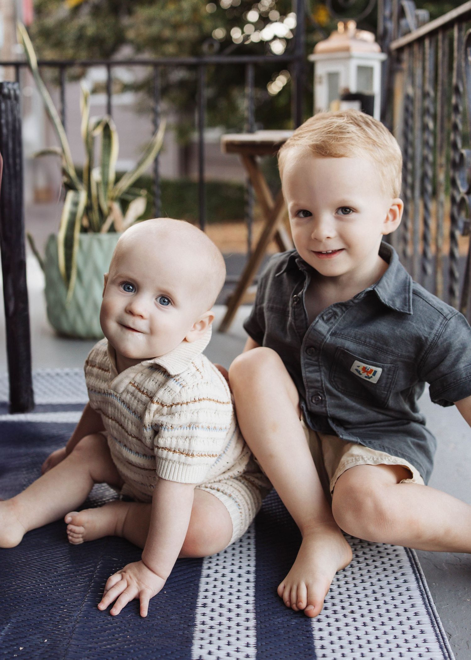 A sequence of candid moments showing two siblings playing together on a patterned floor mat.