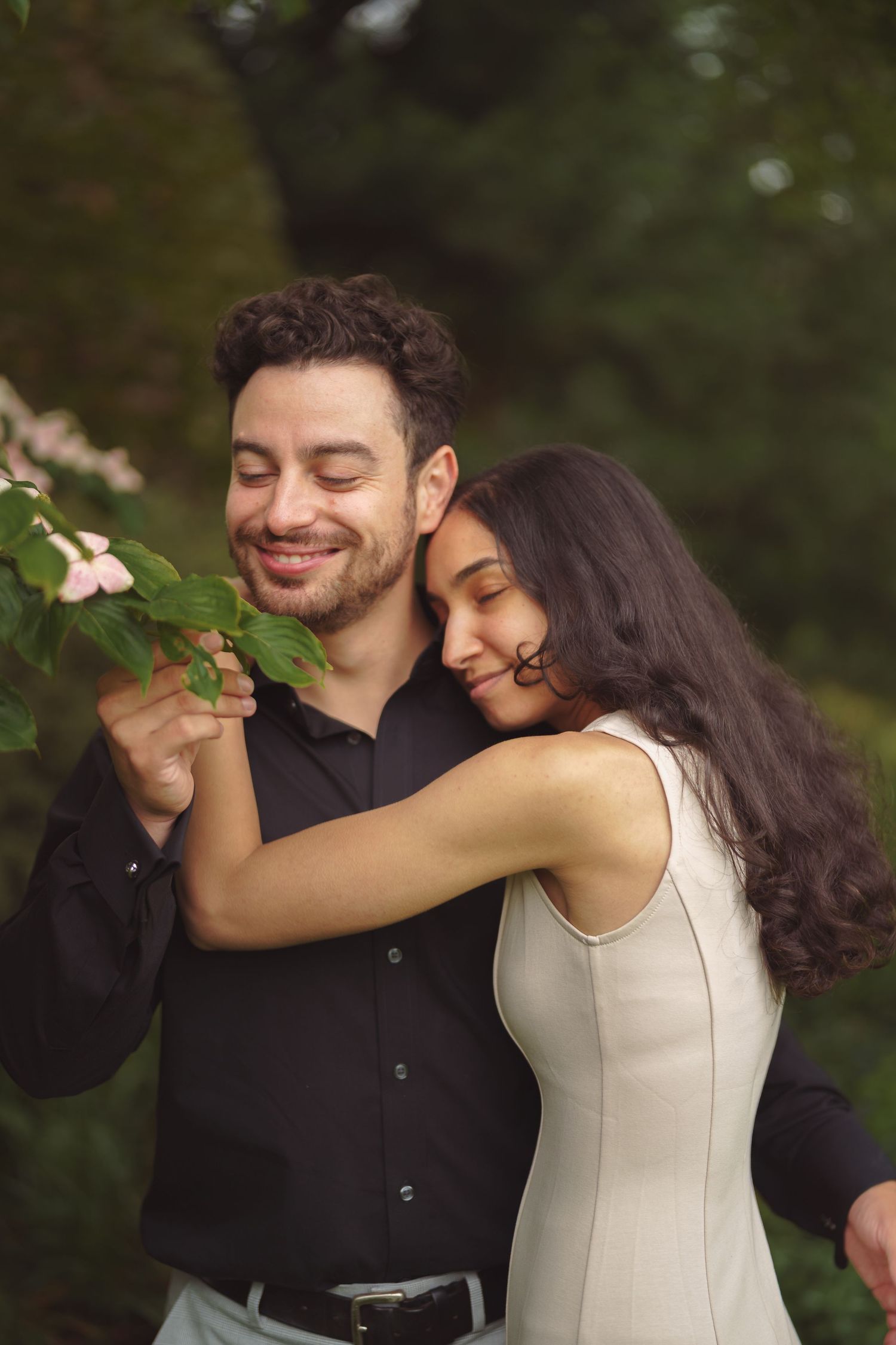 A romantic dancing scene unfolds in a garden with light filtering through the trees.