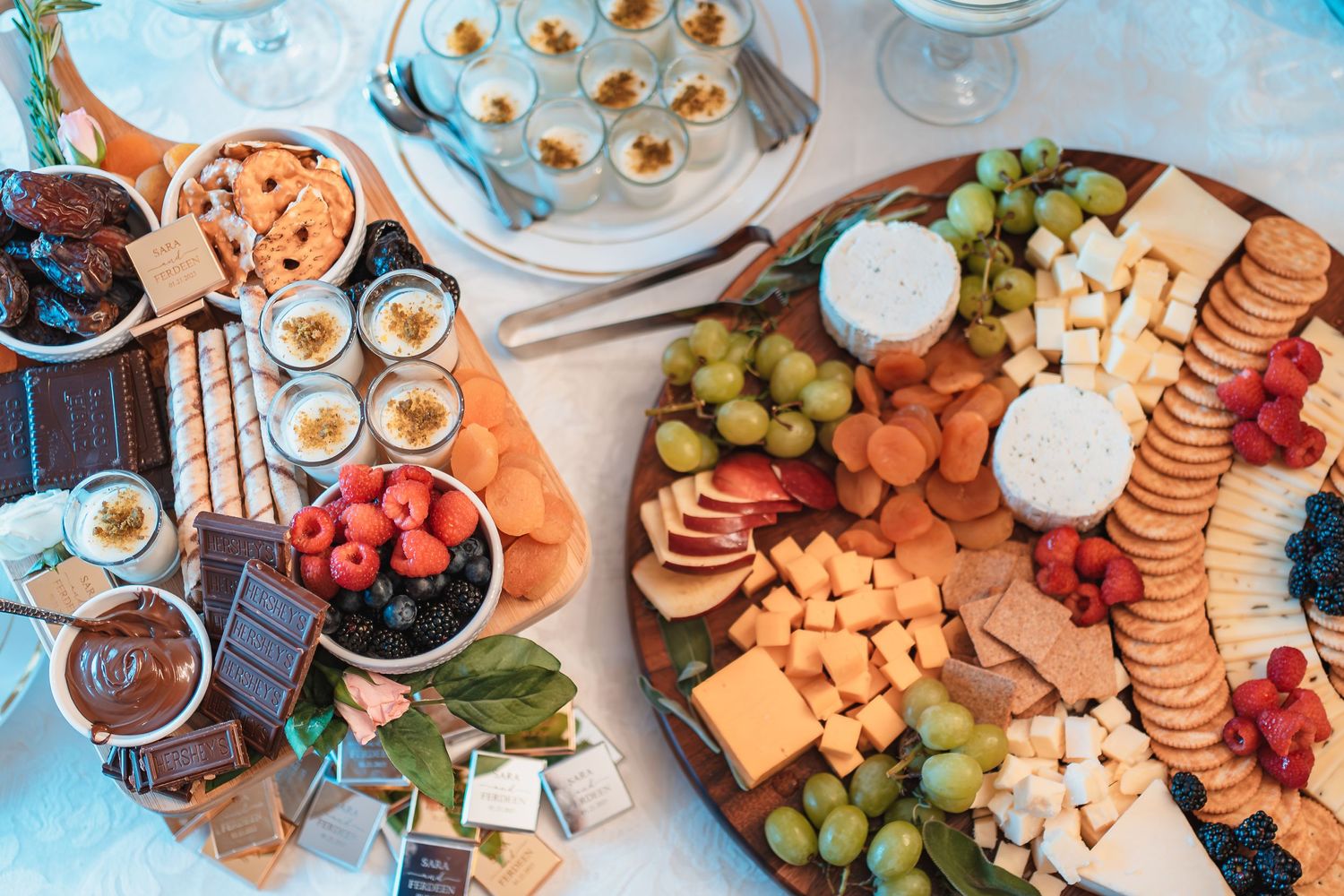 Overhead view of a gourmet cheese and charcuterie board with fruits, crackers and dips.