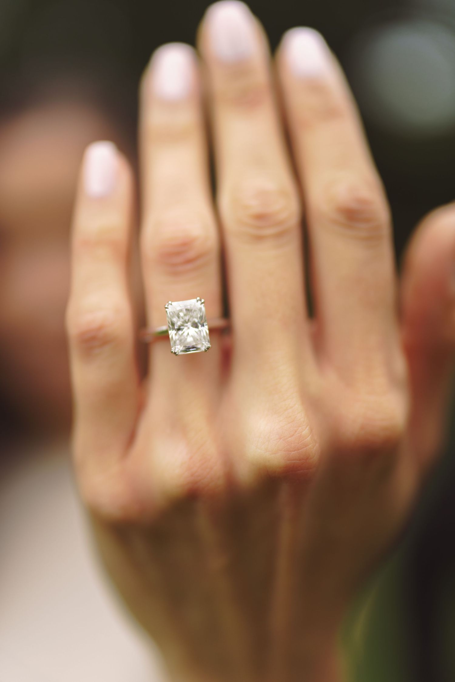 Close up view of a sparkling diamond engagement ring on a hand.