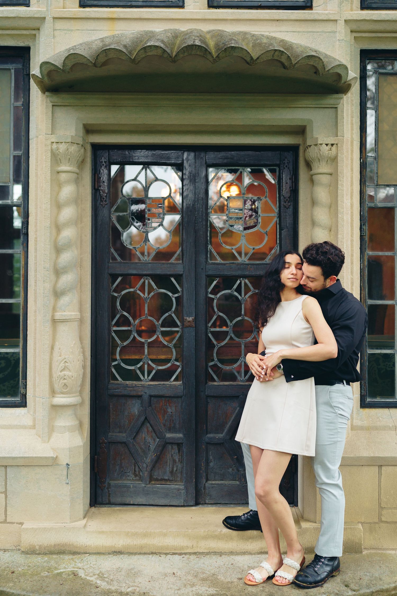 A series of three similar romantic outdoor poses featuring a couple sharing tender moments against ornate stone architecture.