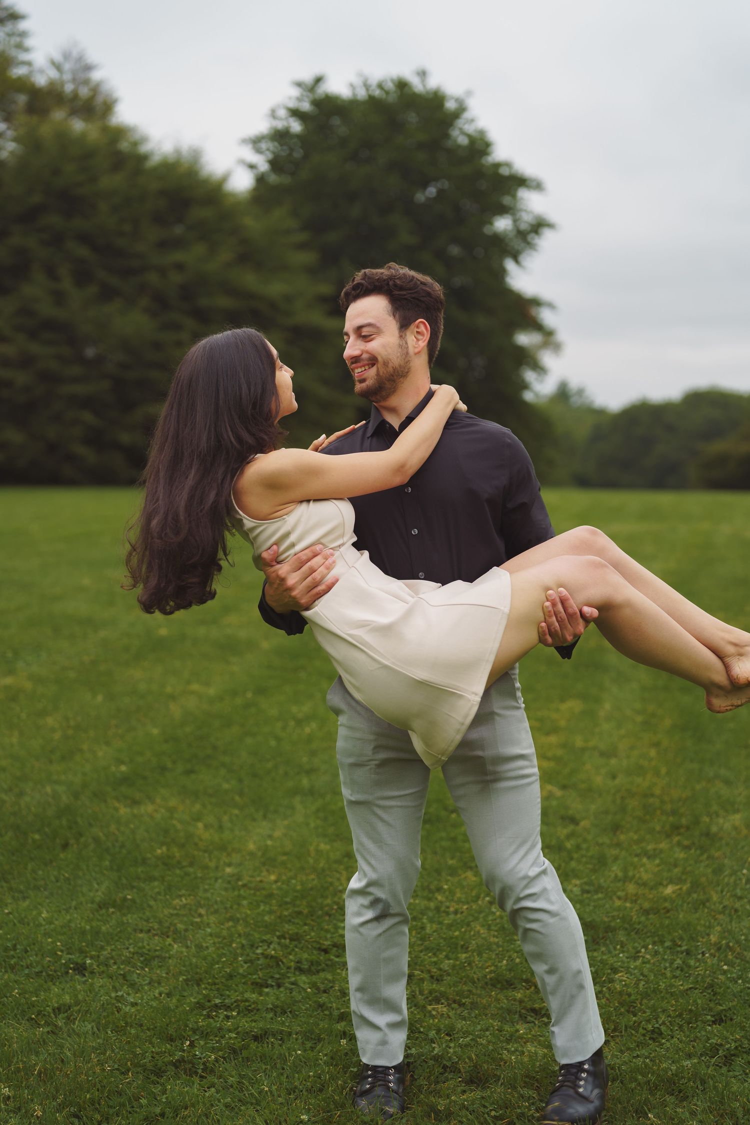 A playful sequence of poses in a green field shows a couple dipping and dancing together.