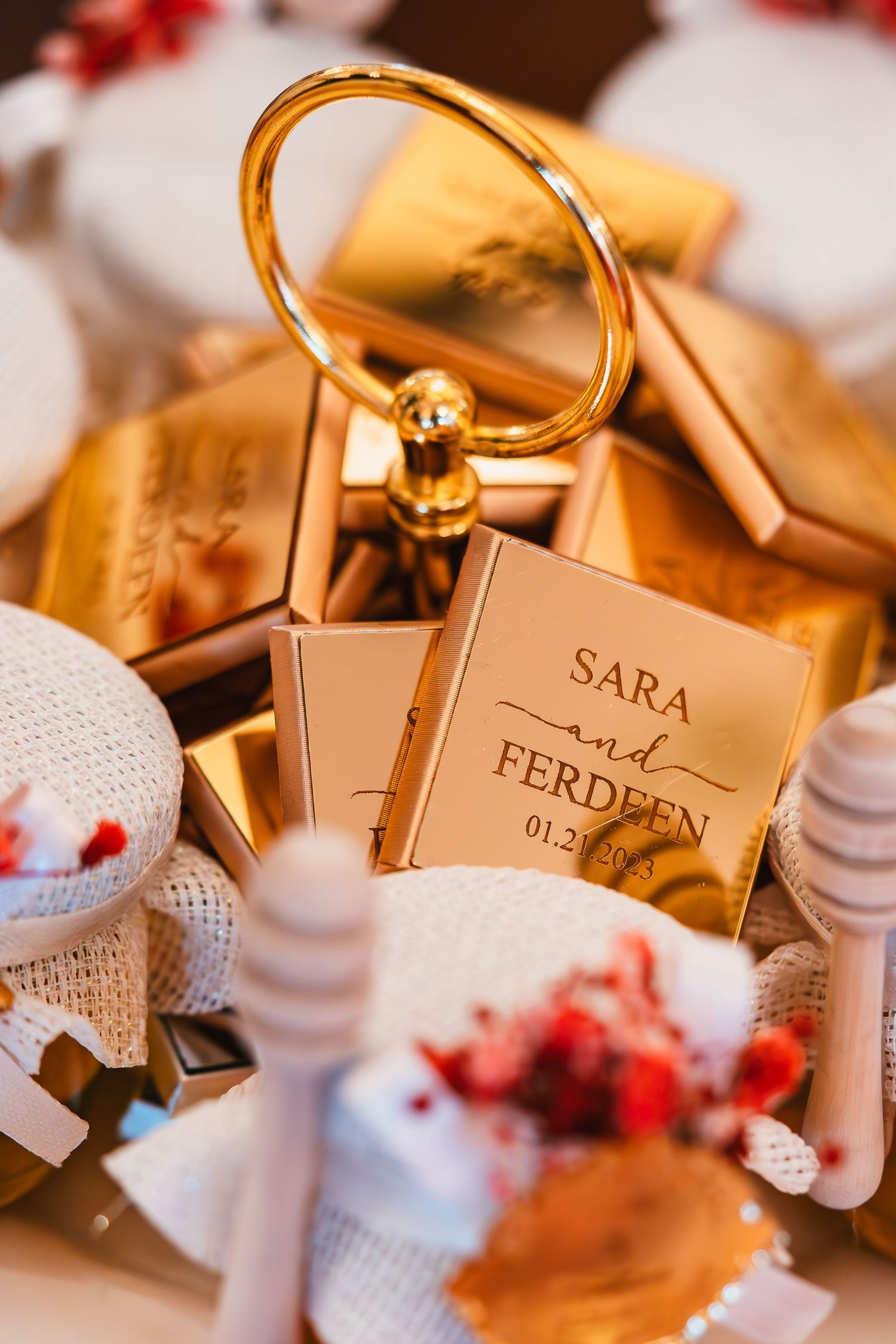 Wedding place cards and gold ring holder displayed with decorative elements.
