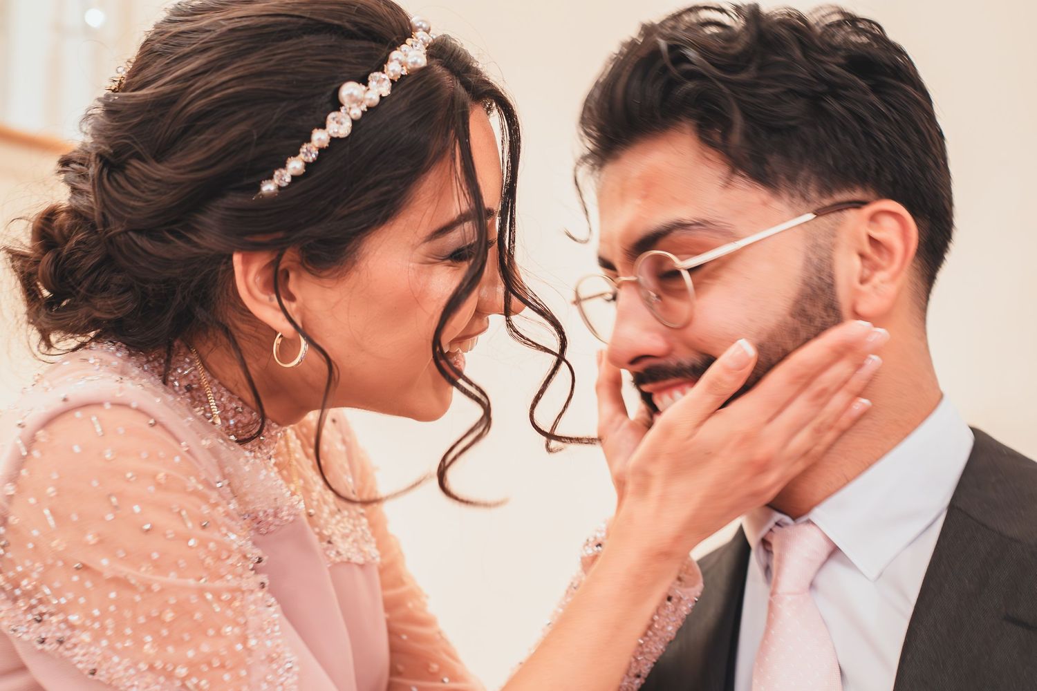 A romantic moment captured between a couple in formal wear with sparkling decorations in the background.