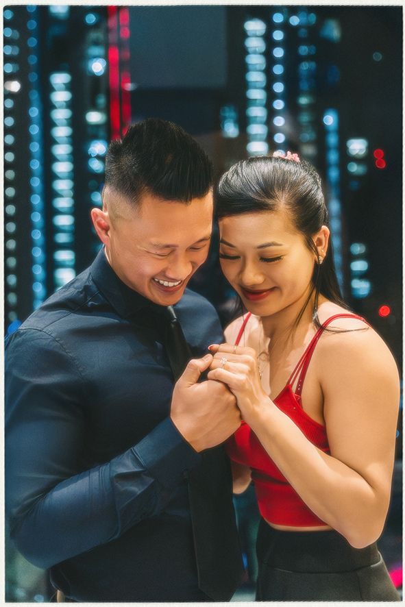 A couple shares a joyful moment together with bokeh lights in the background creating a romantic atmosphere. Proposal Session Seoul Korea