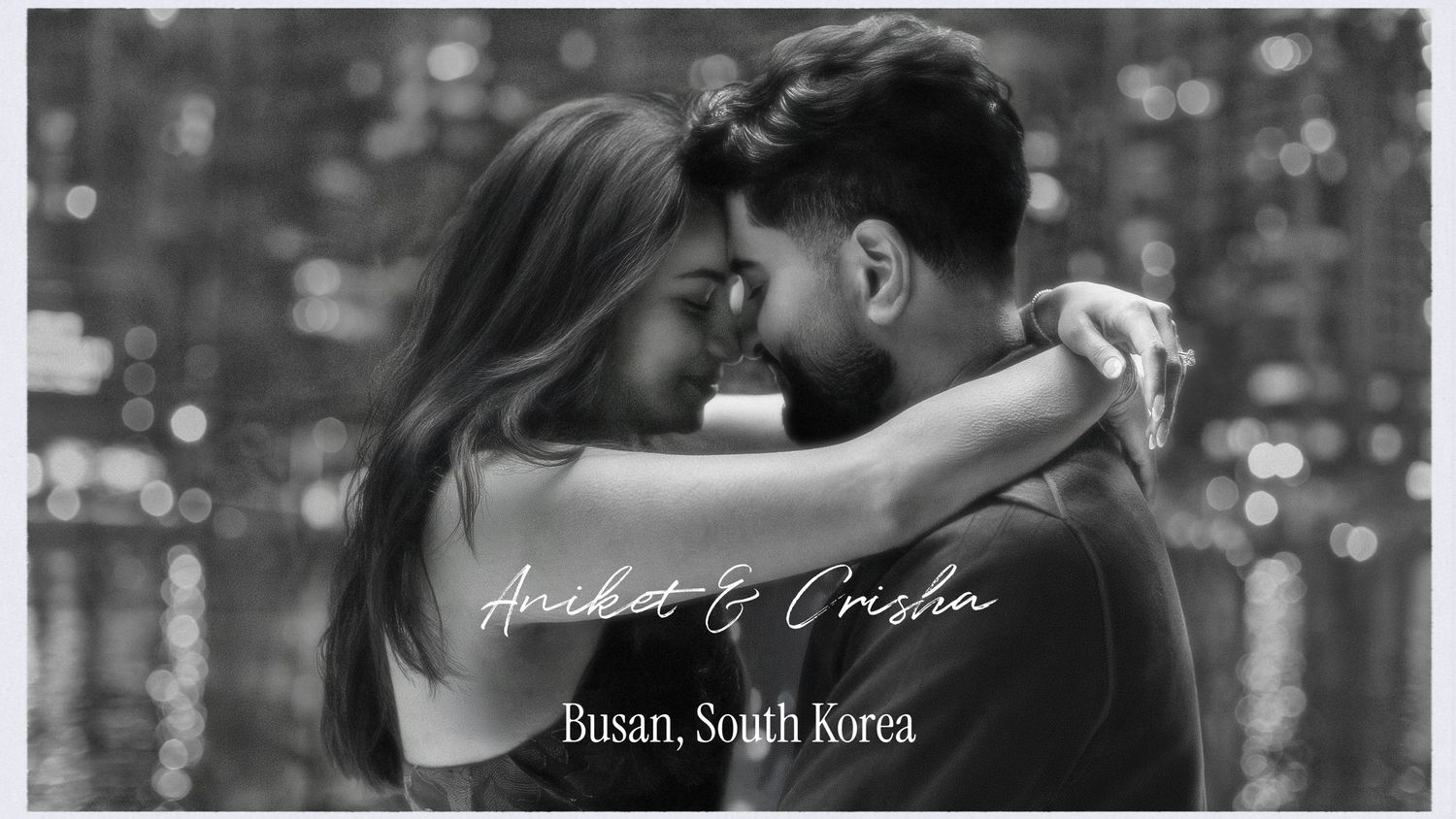 A couple shares an intimate dance in black and white with a bokeh light background in Busan, South Korea.