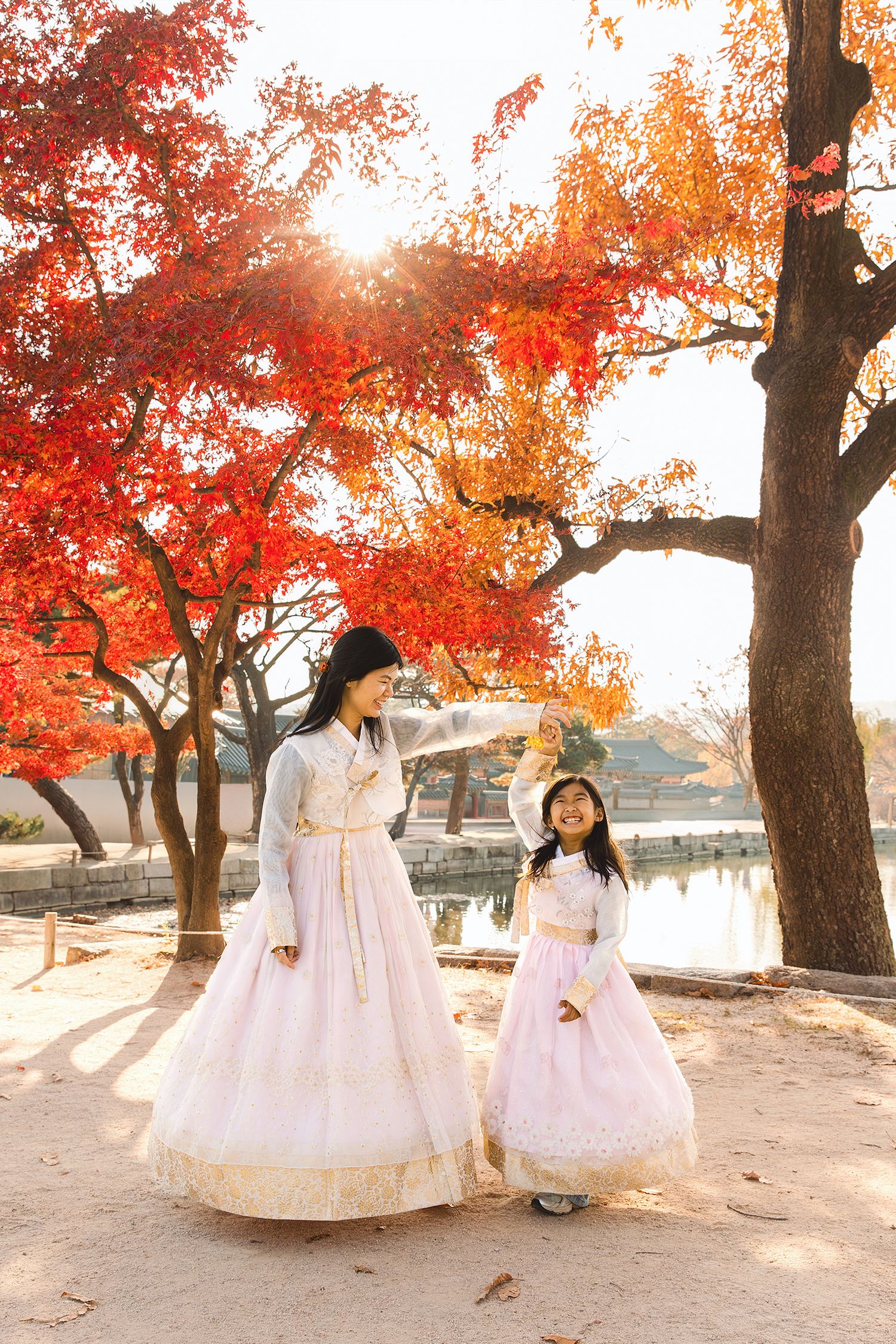 Traditional Korean hanbok dresses shown in a series of photos under vibrant red autumn maple trees at sunset.