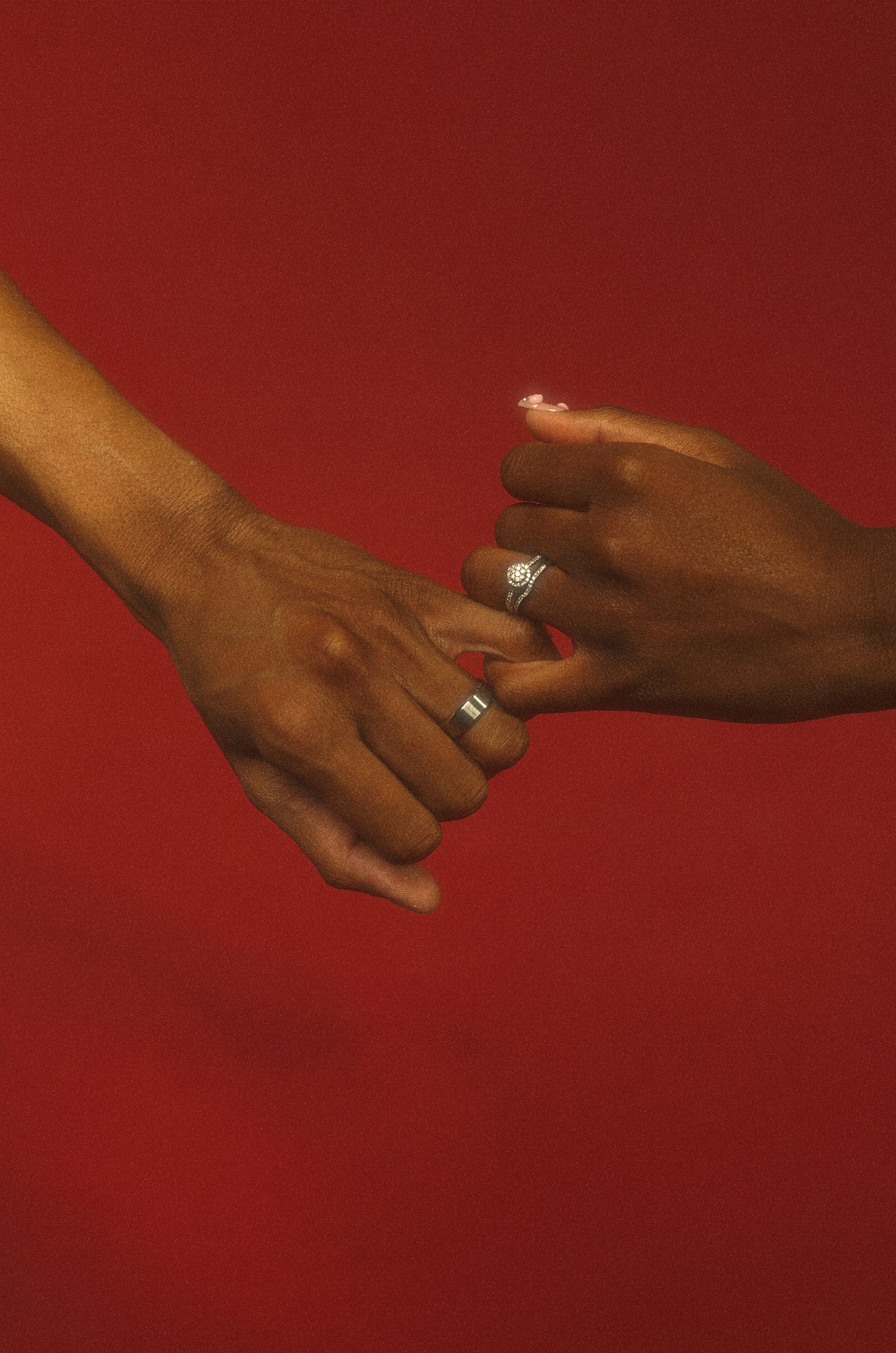 Close-up sequence showing hands with engagement ring against a deep red background.