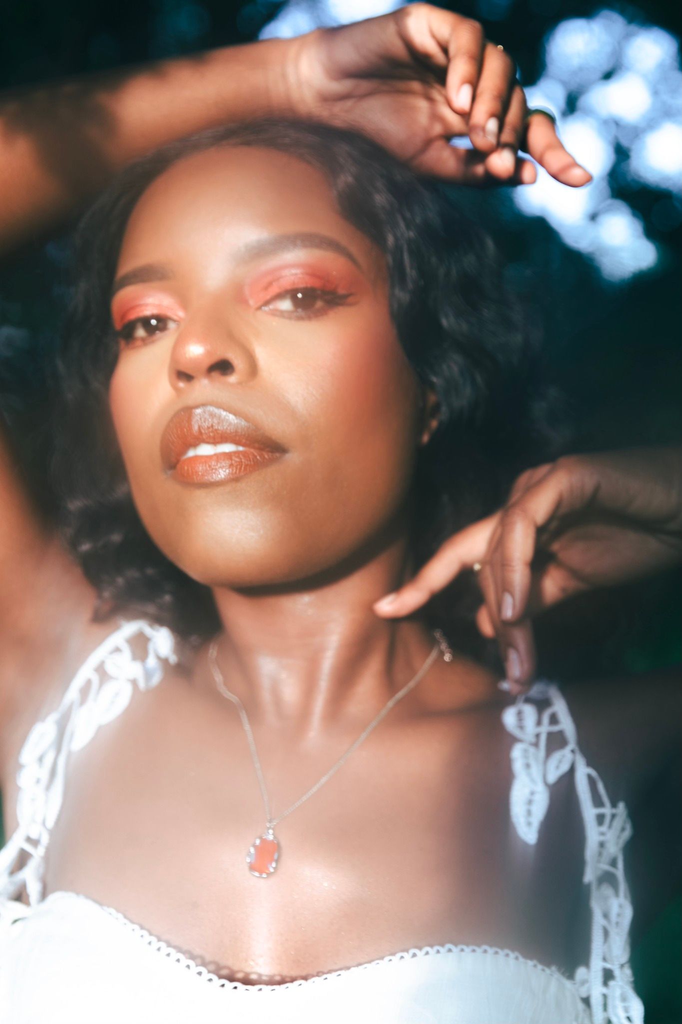 Close-up fashion portrait at dusk with dreamy bokeh lighting and soft natural glow.