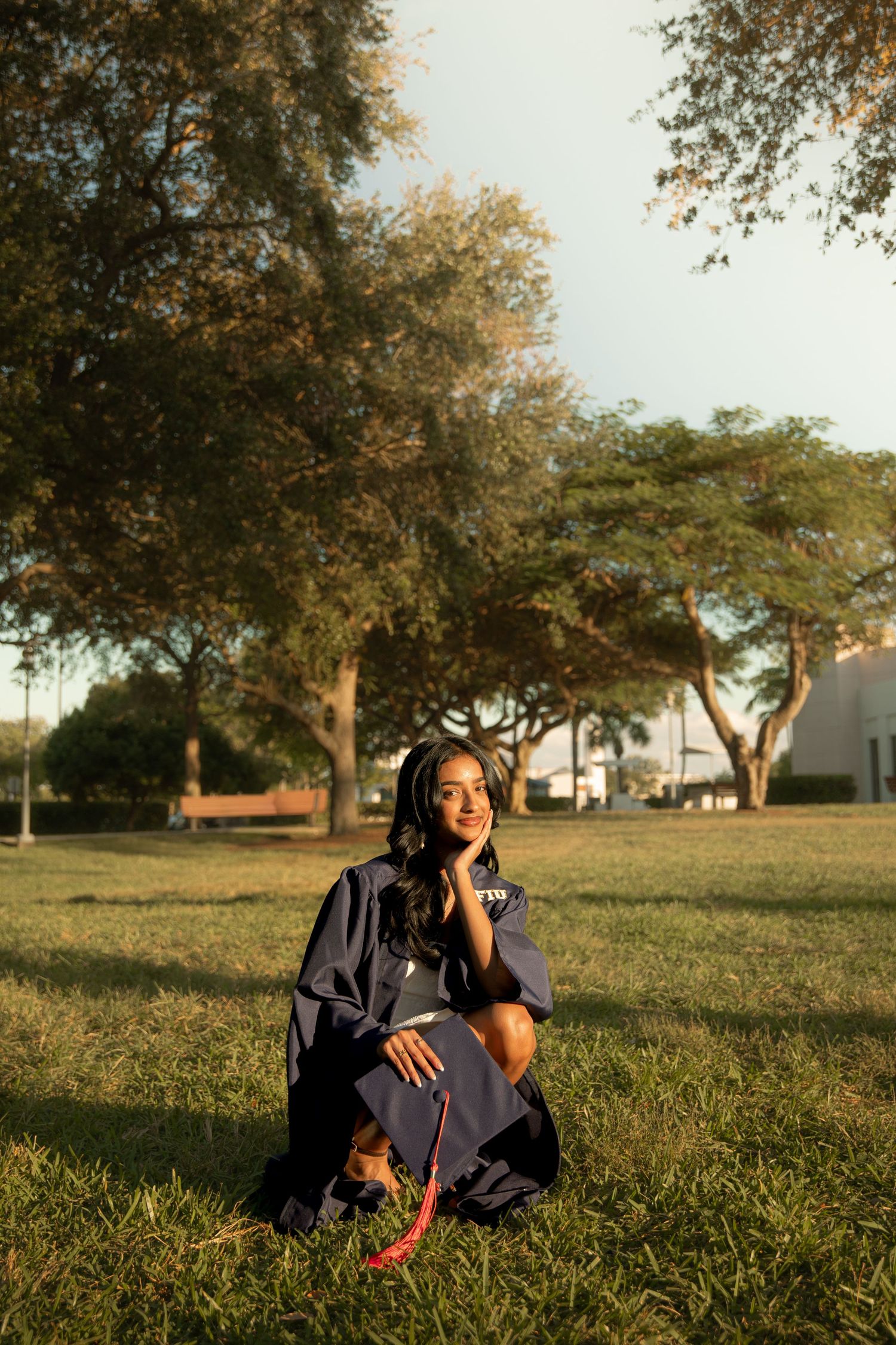 Person lounging on grass during golden hour with vintage camera equipment.