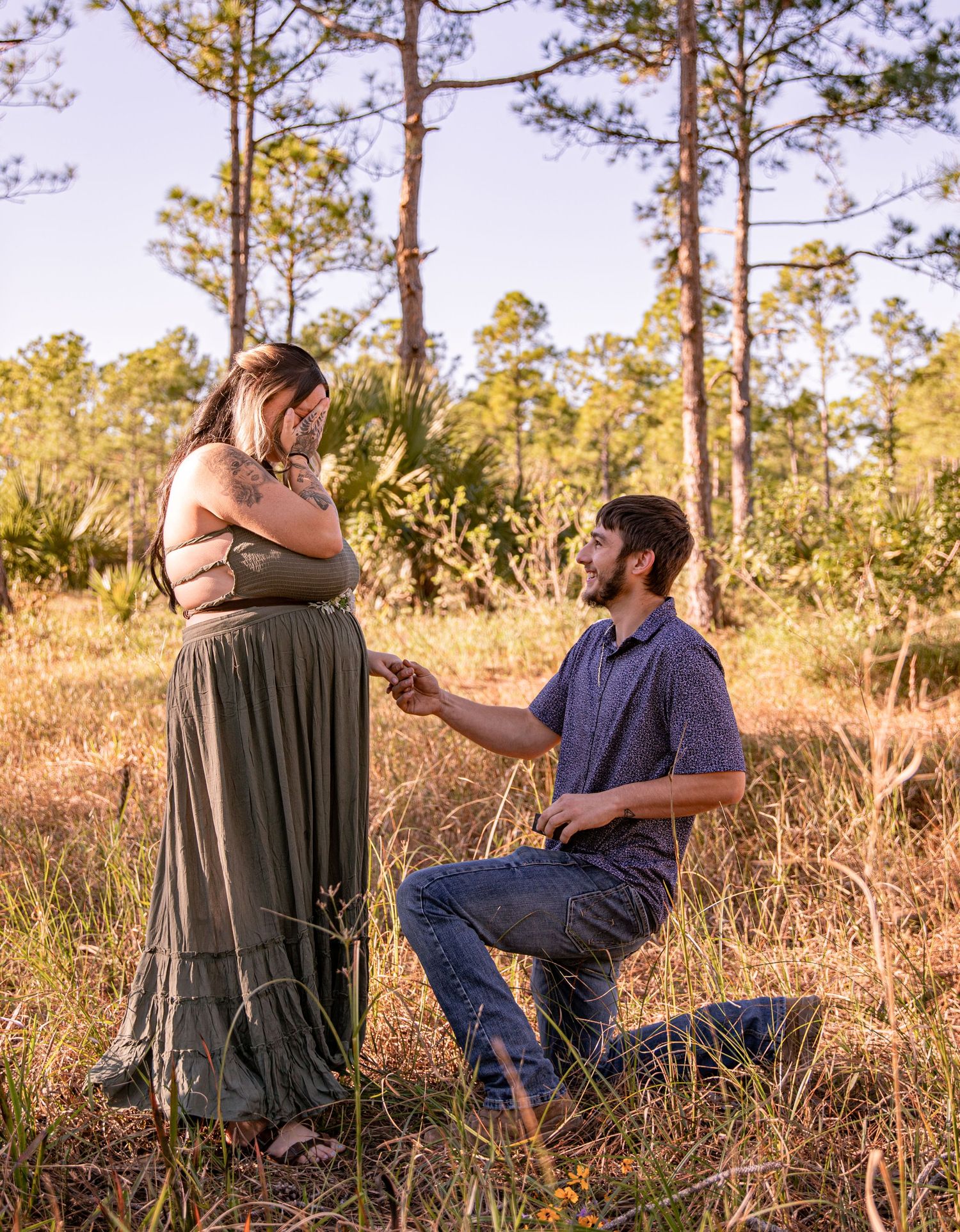 A proposal scene at sunset with pine trees in the background.