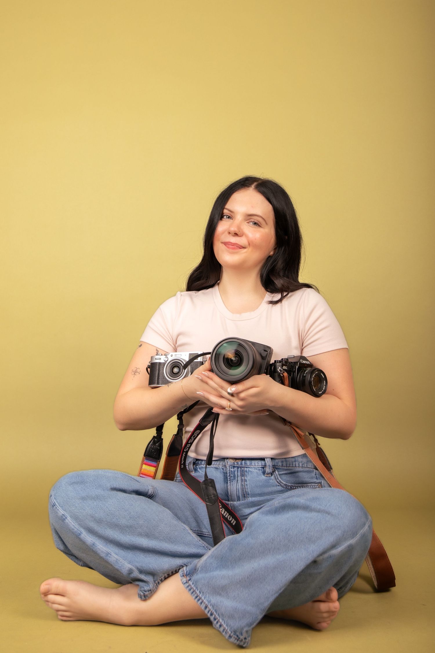 Casual portrait series showing photographer with vintage cameras on yellow background.