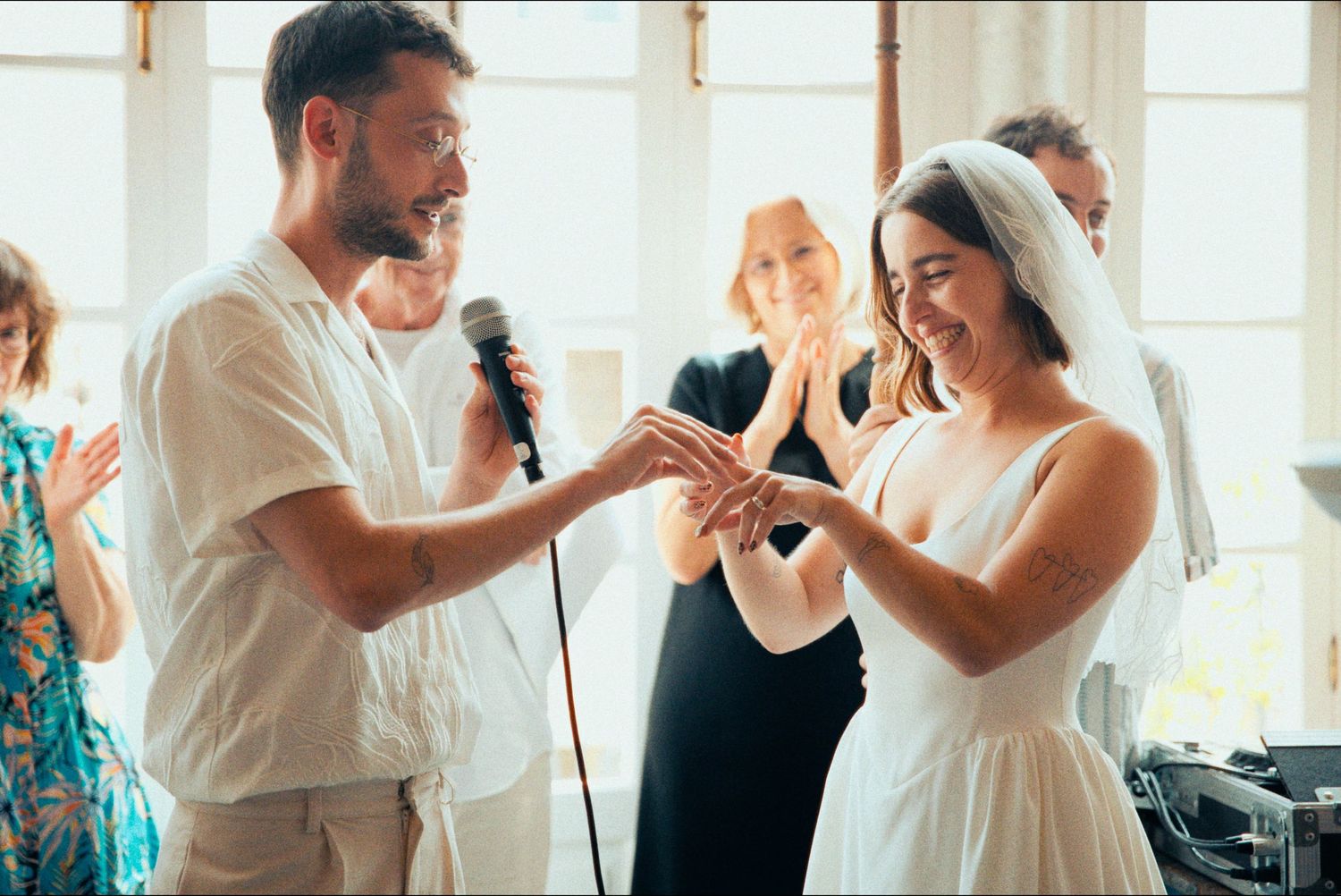Wedding celebration with people dancing and enjoying themselves in a bright venue.